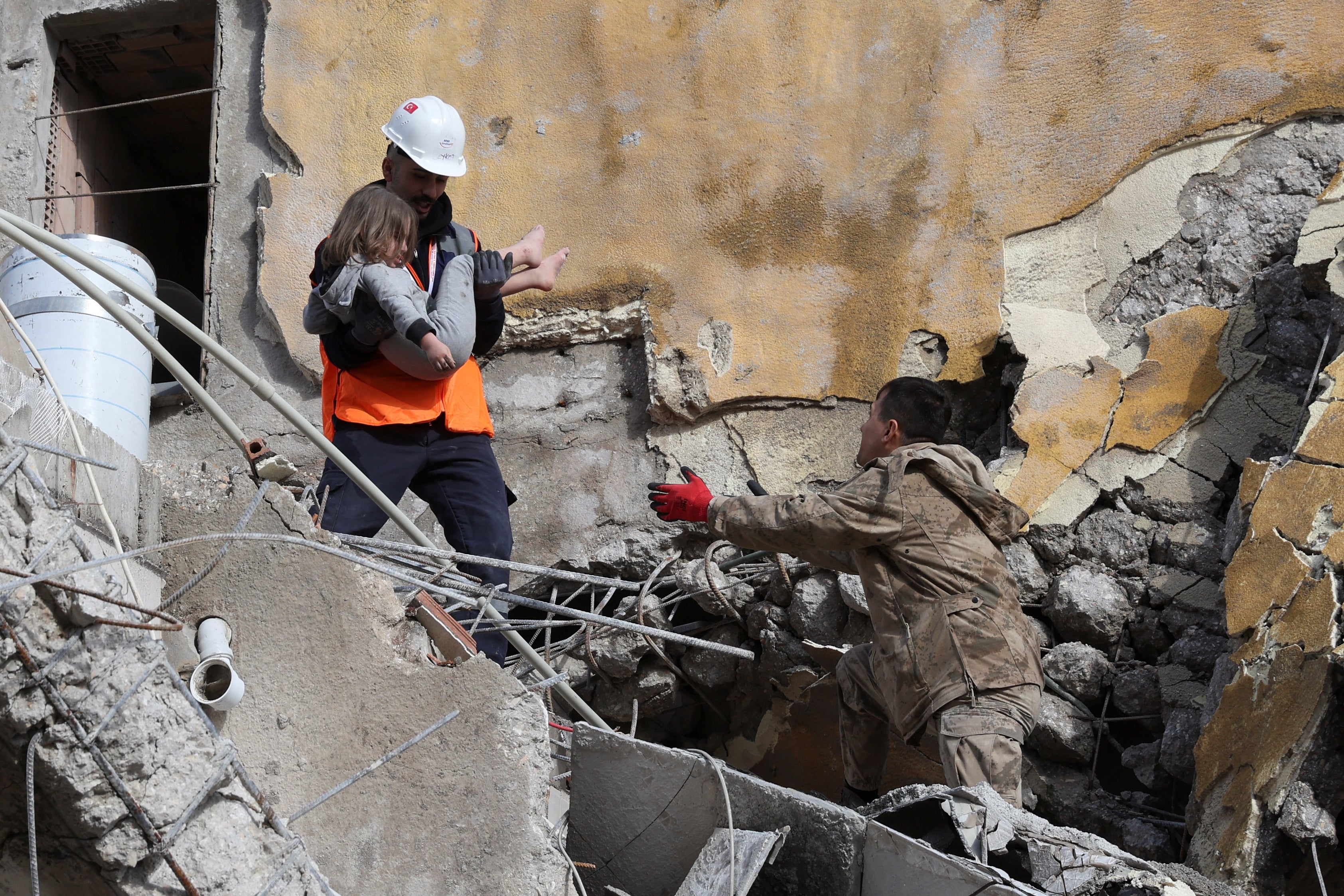 Muhammet Ruzgar, 5, is carried out by rescuers from the site of a damaged building, following an earthquake in Hatay, Turkey, February 7