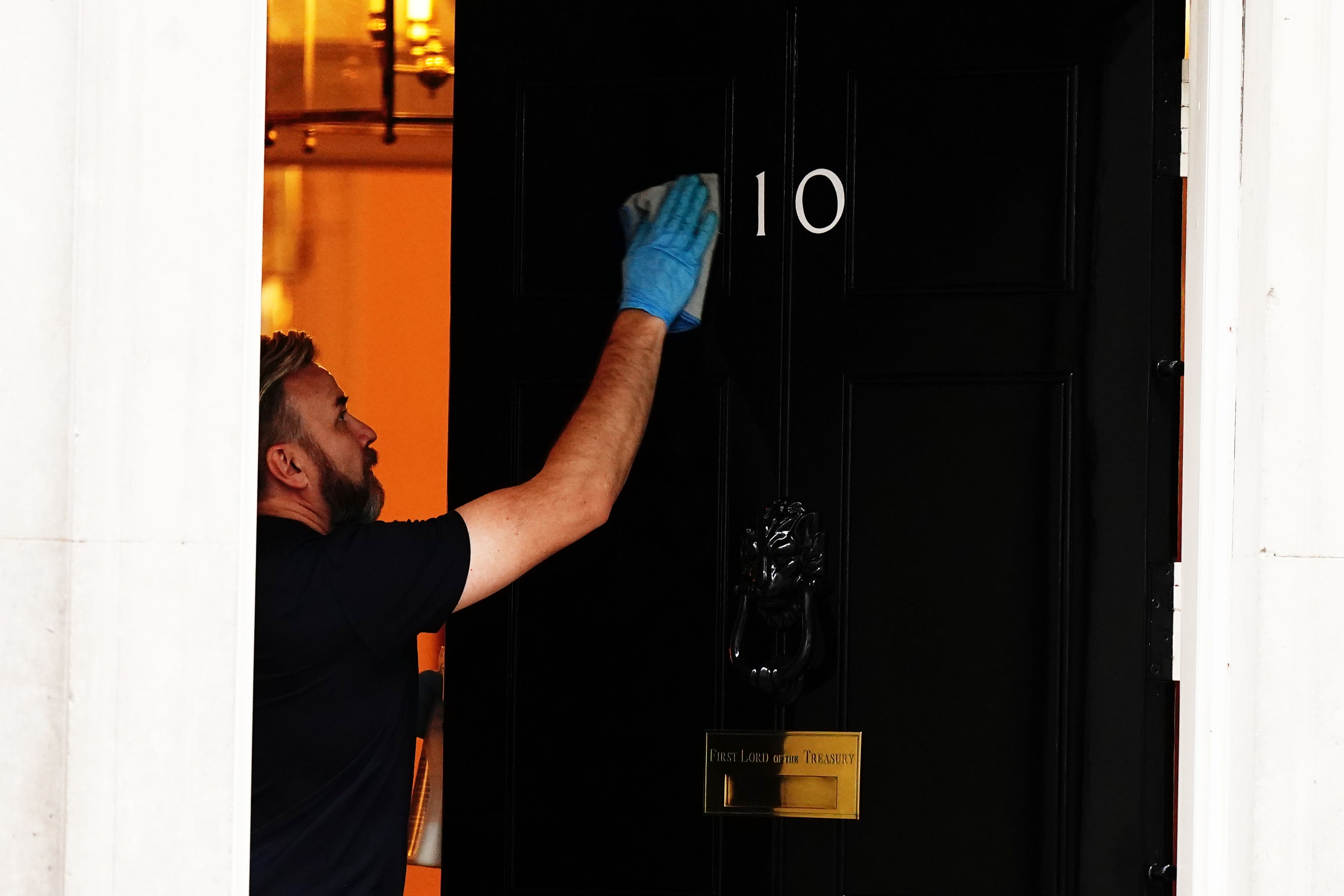 A person cleans the front door of 10 Downing Street, London. But department organisation is not simply a matter of changing a few signs (Aaron Chown/PA)