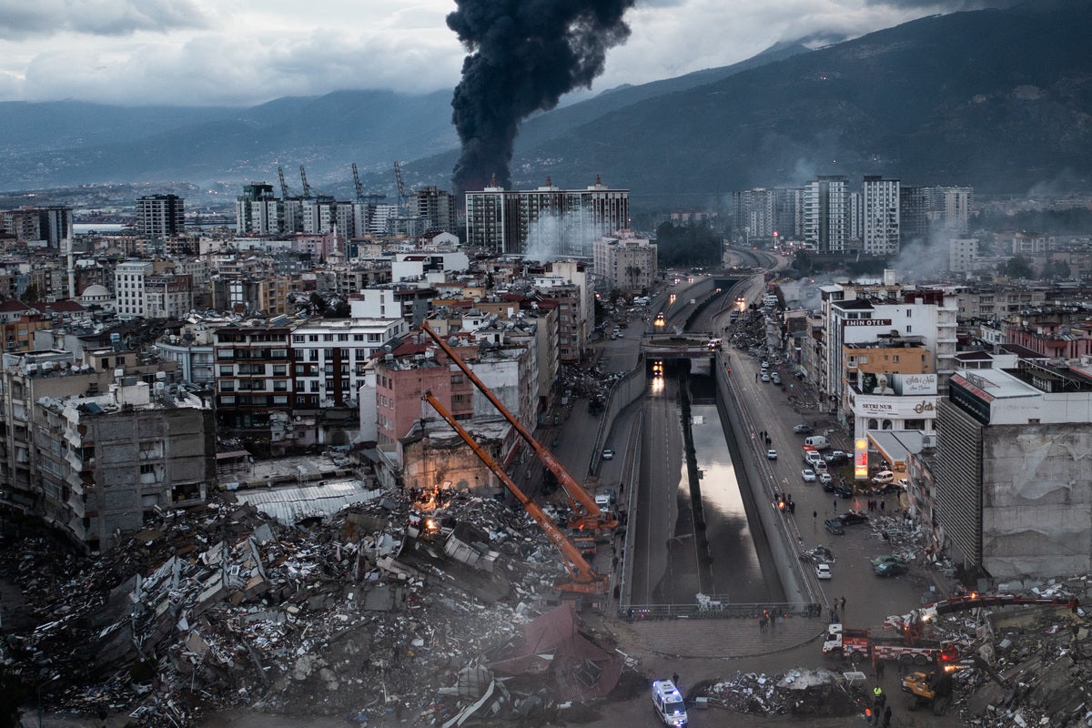 After: Smoke billows from the Iskenderun Port as rescue workers work at the scene of a collapsed building on February 07, 2023 in Iskenderun, Turkey