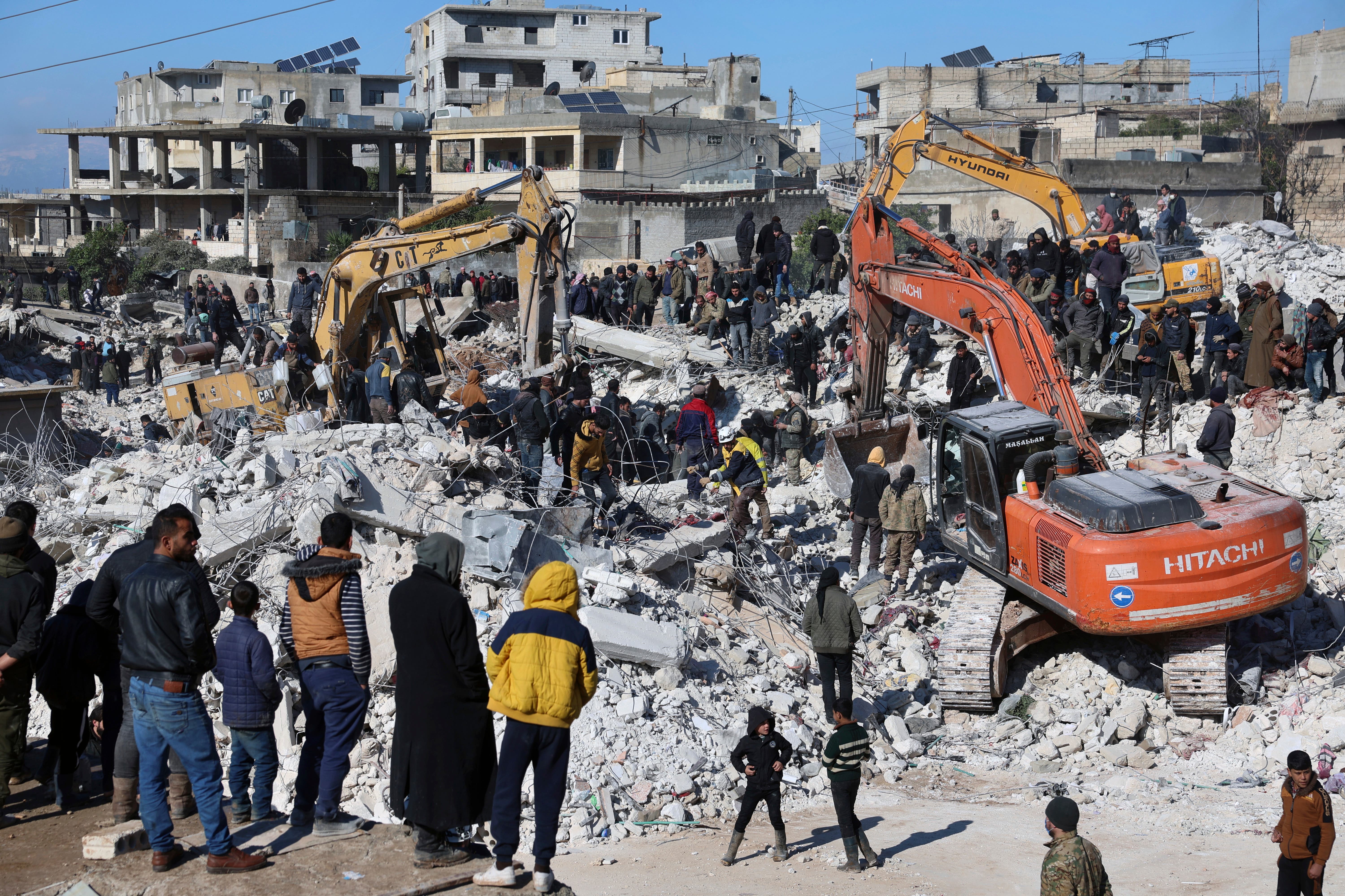 Rescuers and residents search through the rubble of collapsed buildings in the town of Harem near the Turkish border, Idlib province, Syria, Wednesday, Feb. 8, 2023. With the hope of finding survivors fading, stretched rescue teams in Turkey and Syria searched Wednesday for signs of life in the rubble of thousands of buildings toppled by a catastrophic earthquake. (AP Photo/Ghaith Alsayed)