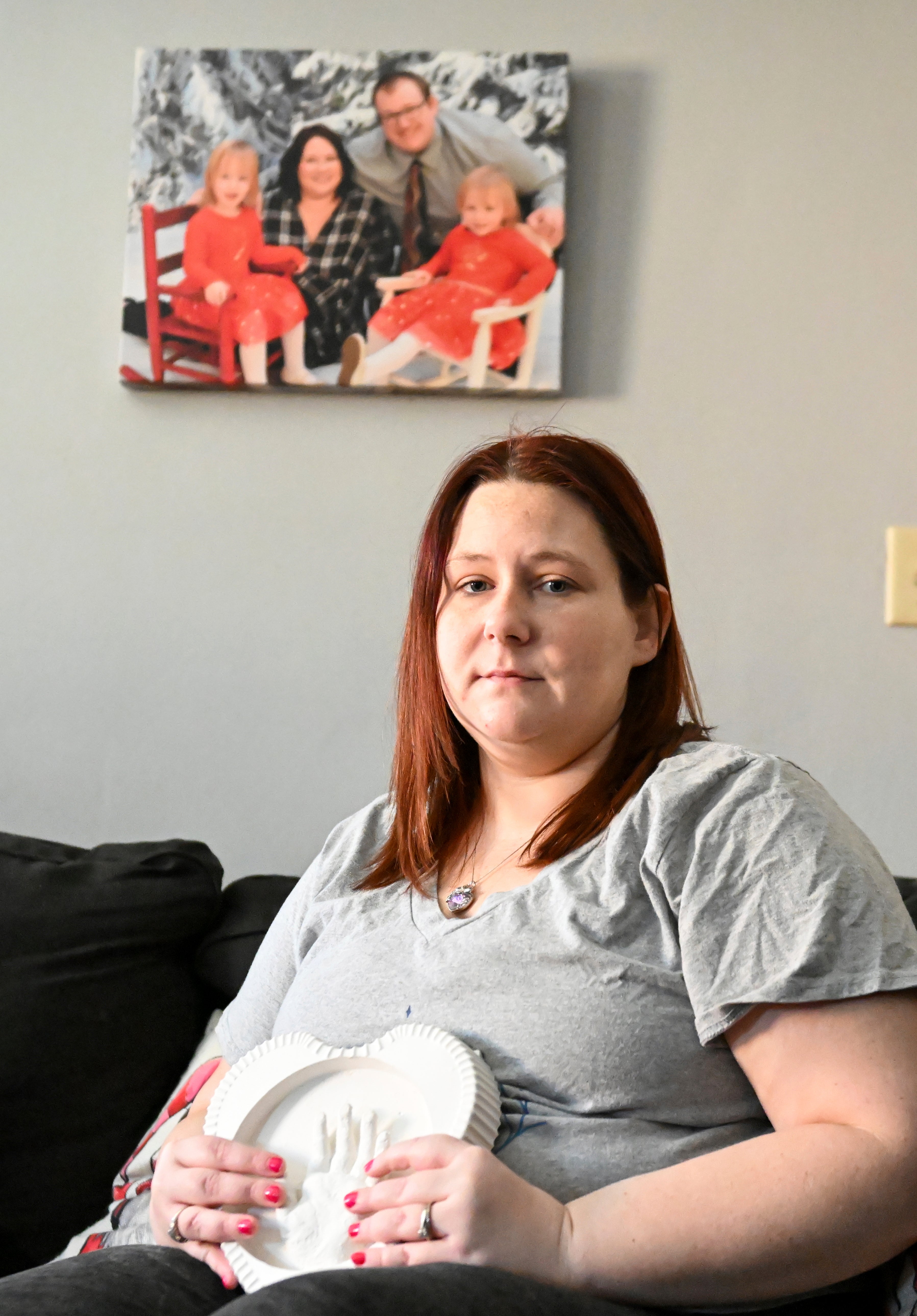 Jessica Day-Weaver holds a ceramic hand print of her daughter, Anastasia, at her home, Thursday, Feb. 2, 2022, in Boardman, Ohio