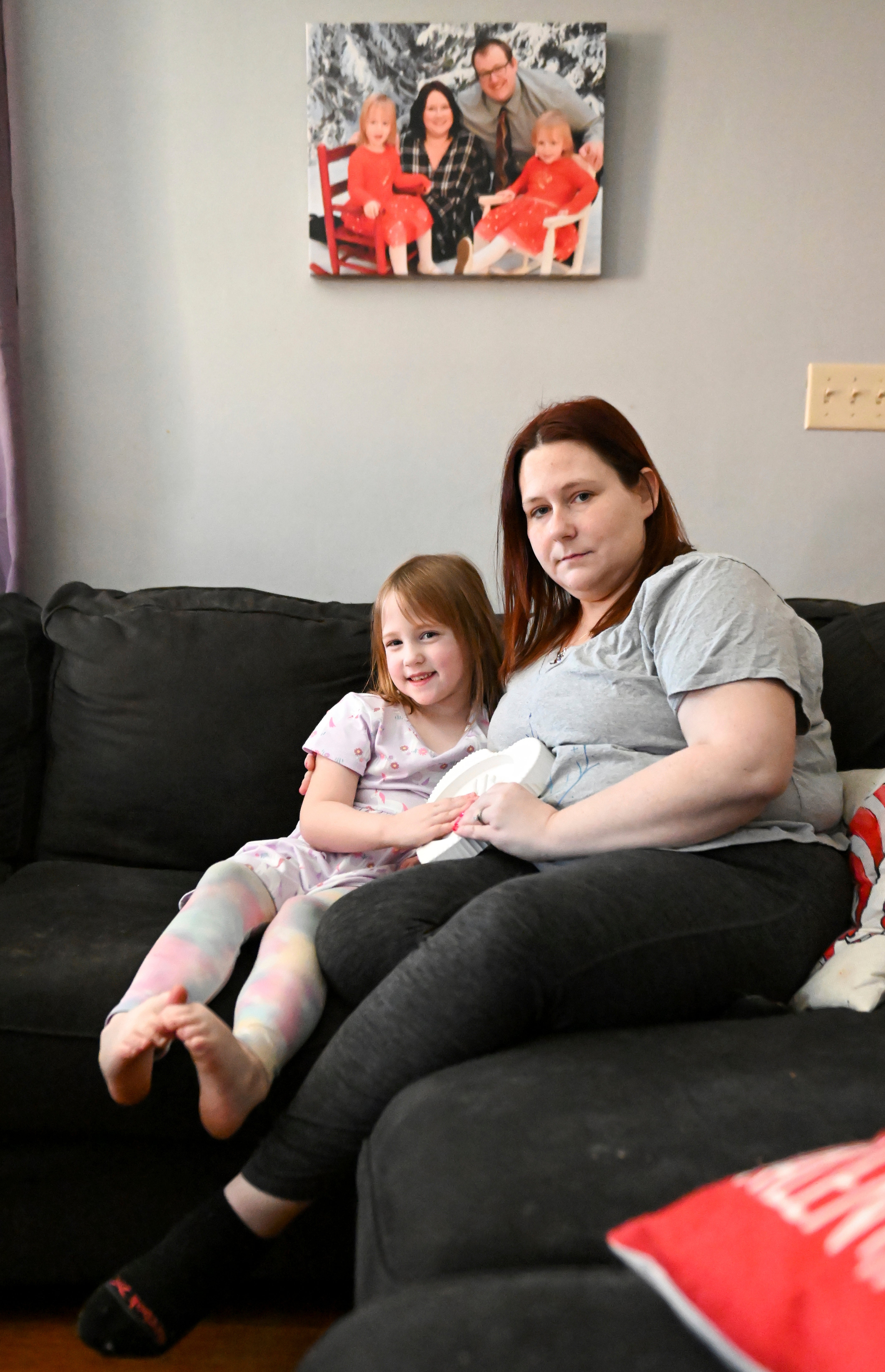 Jessica Day-Weaver, right, and Caitlin Weaver hold a ceramic hand print of daughter, Anastasia, at their home Thursday, Feb. 2, 2022, in Boardman, Ohio