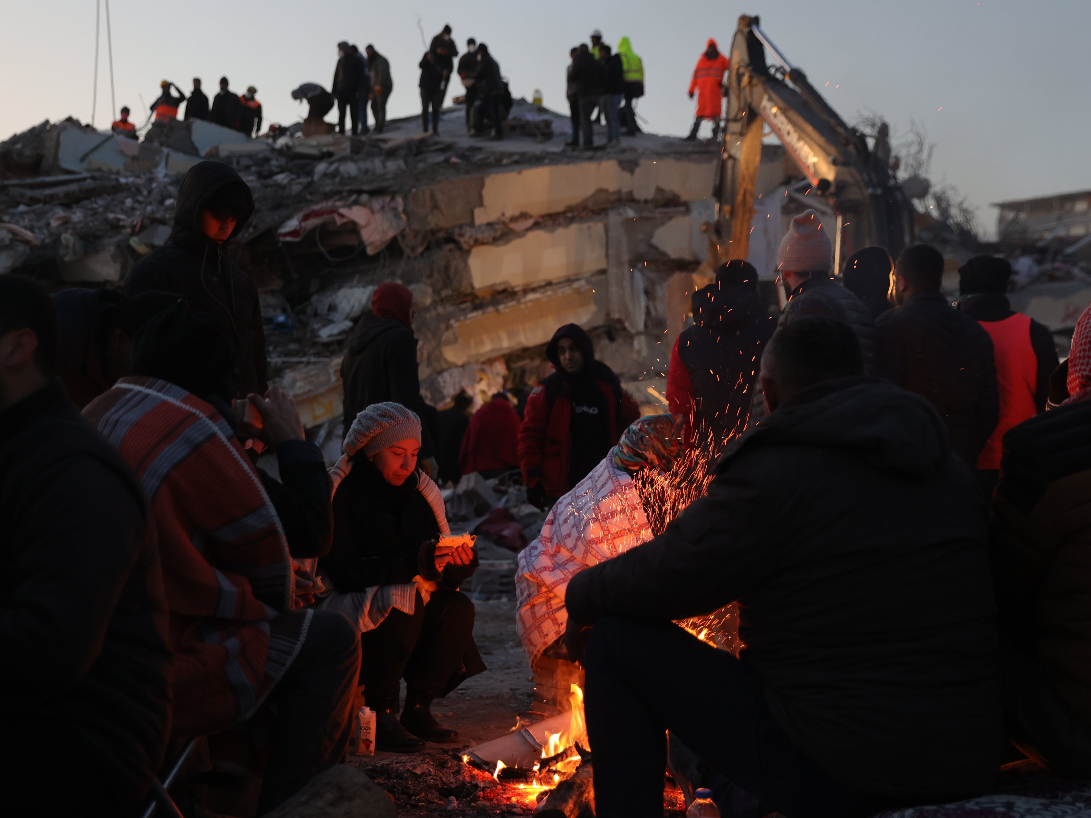 People are keeping warm with bonfires amid the rubble