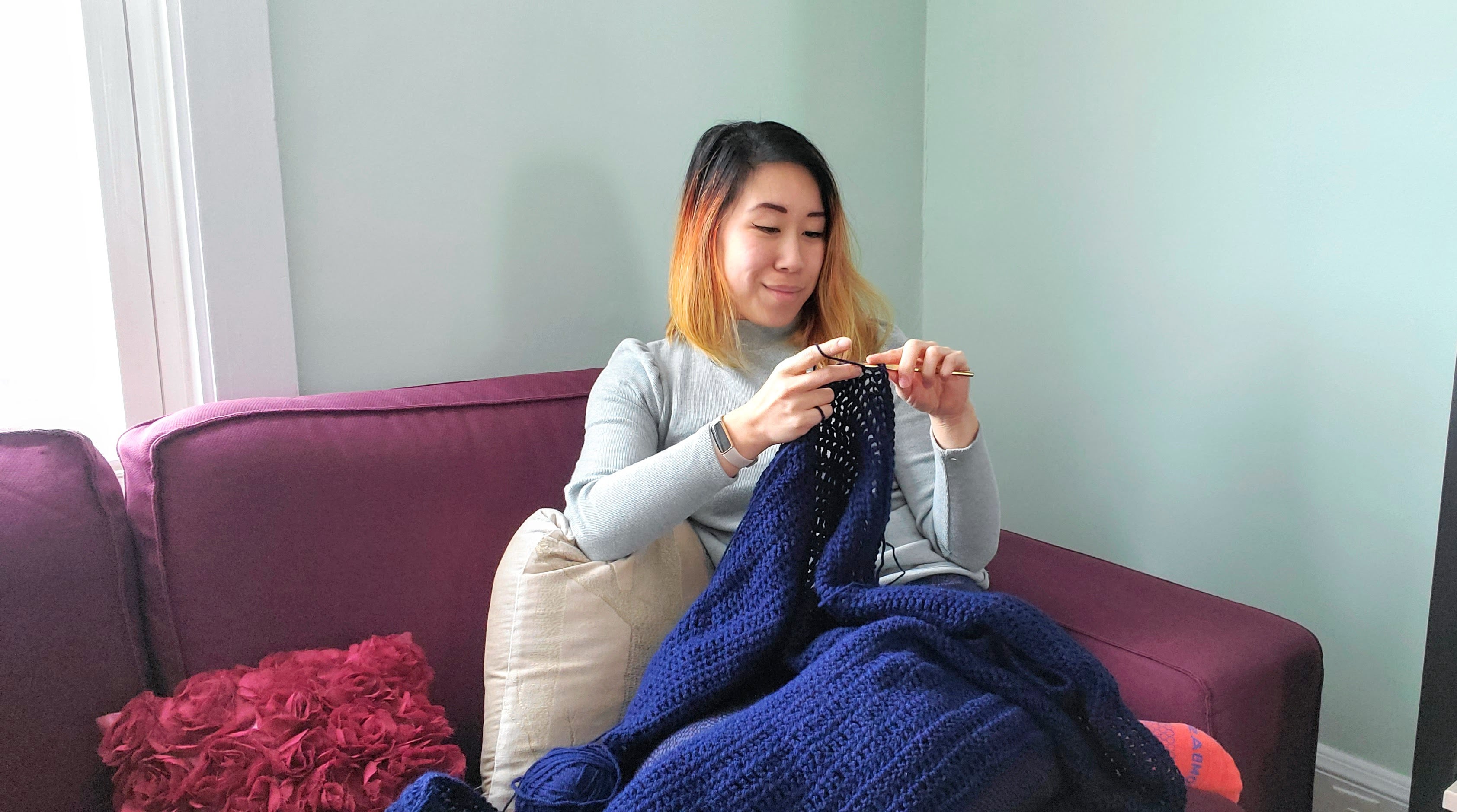 Eugenia Opuda, a volunteer finisher for Loose Ends, crochets a blanket in her home in Portland