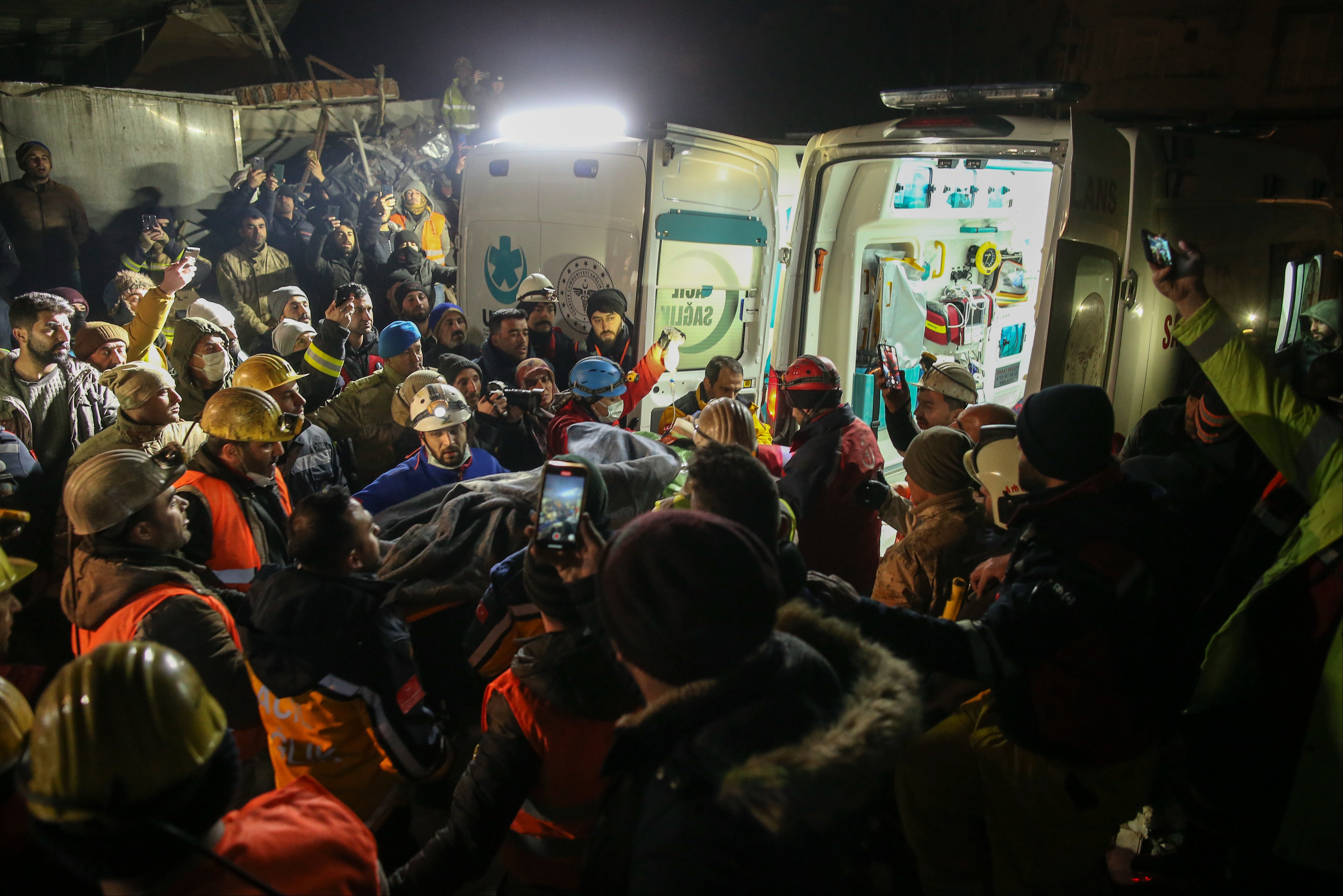 Rescue workers pull out a young woman from a collapsed building in Adiyaman, southern Turkey