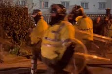 Riot police called to protests outside asylum-seeker hotel as police van set on fire