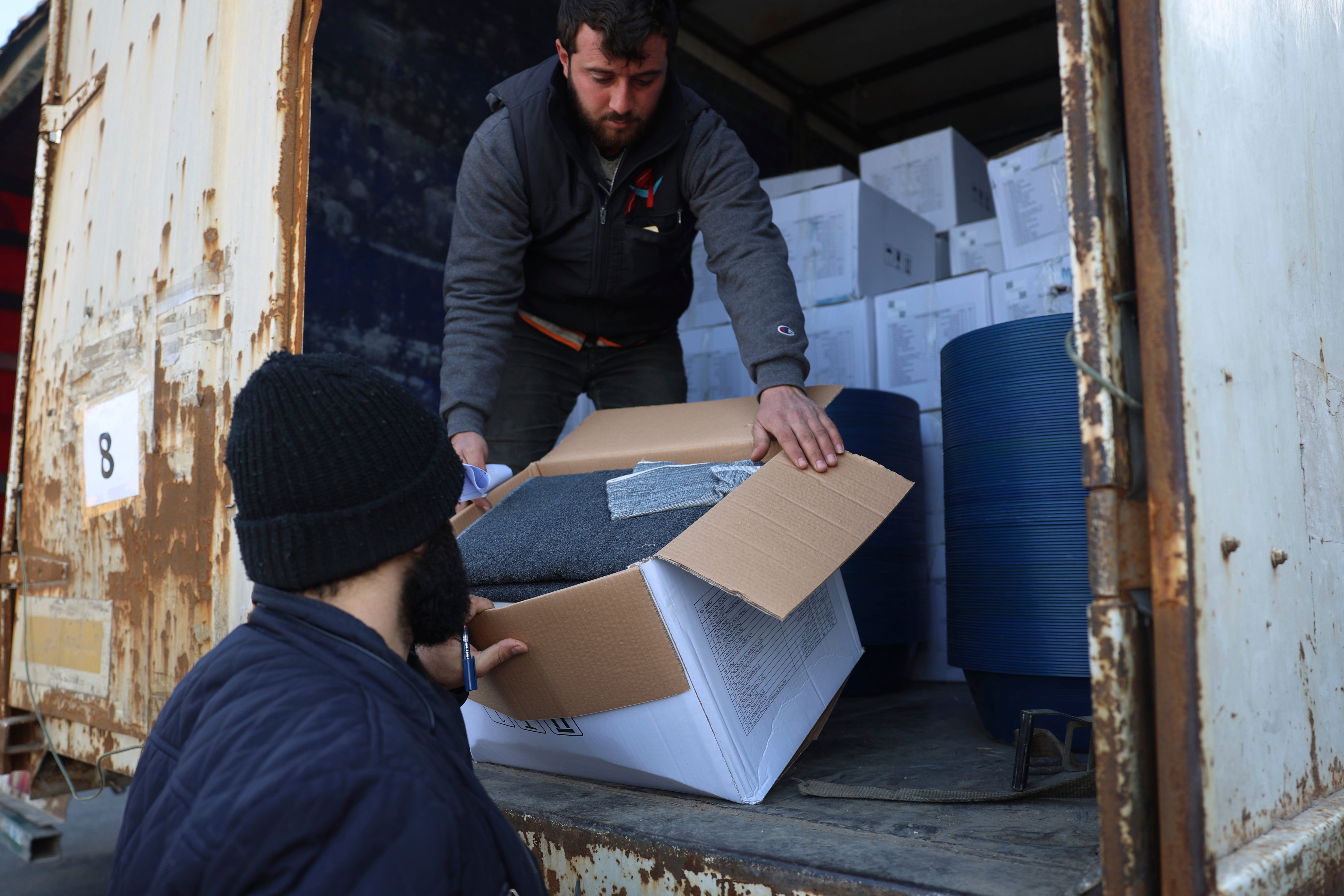 Border customs officials inspect a truck loaded with UN humanitarian aid for Syria