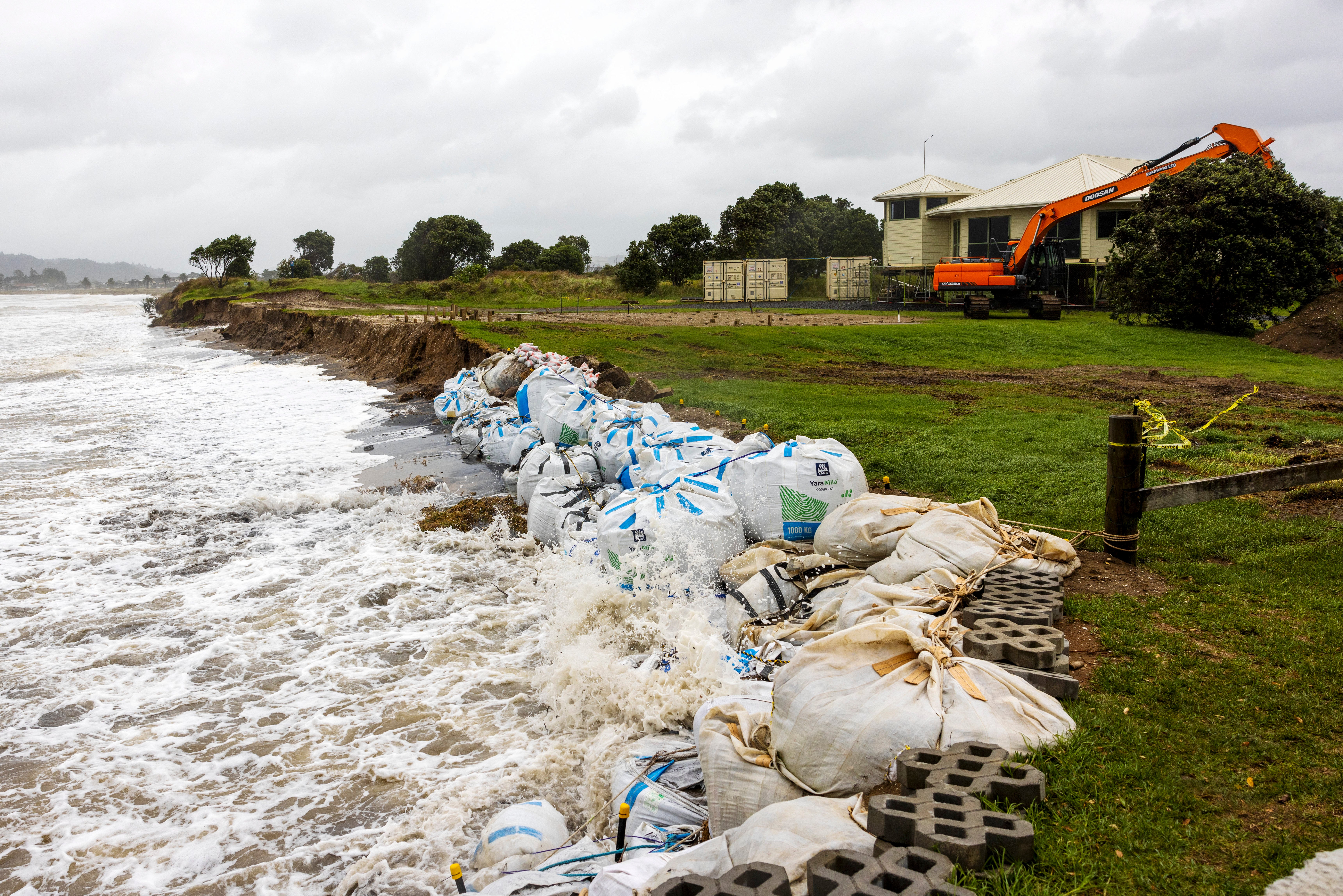 Sand bags are placed along the coastline as Cyclone Gabrielle buffets the Coromandel, south of Auckland, Sunday