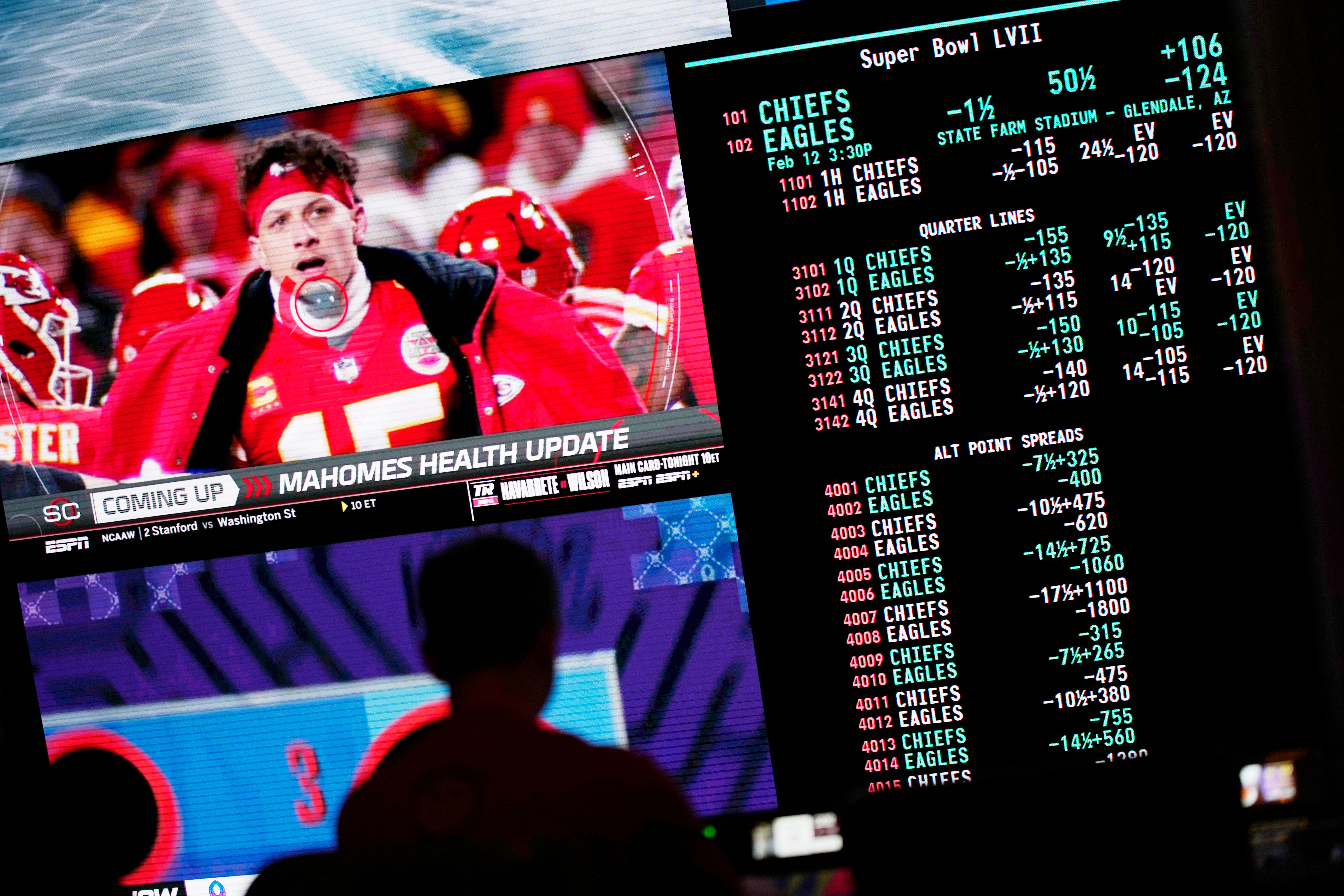 A person gambles as betting odds for NFL football’s Super Bowl are displayed on monitors at the Circa resort and casino sports book