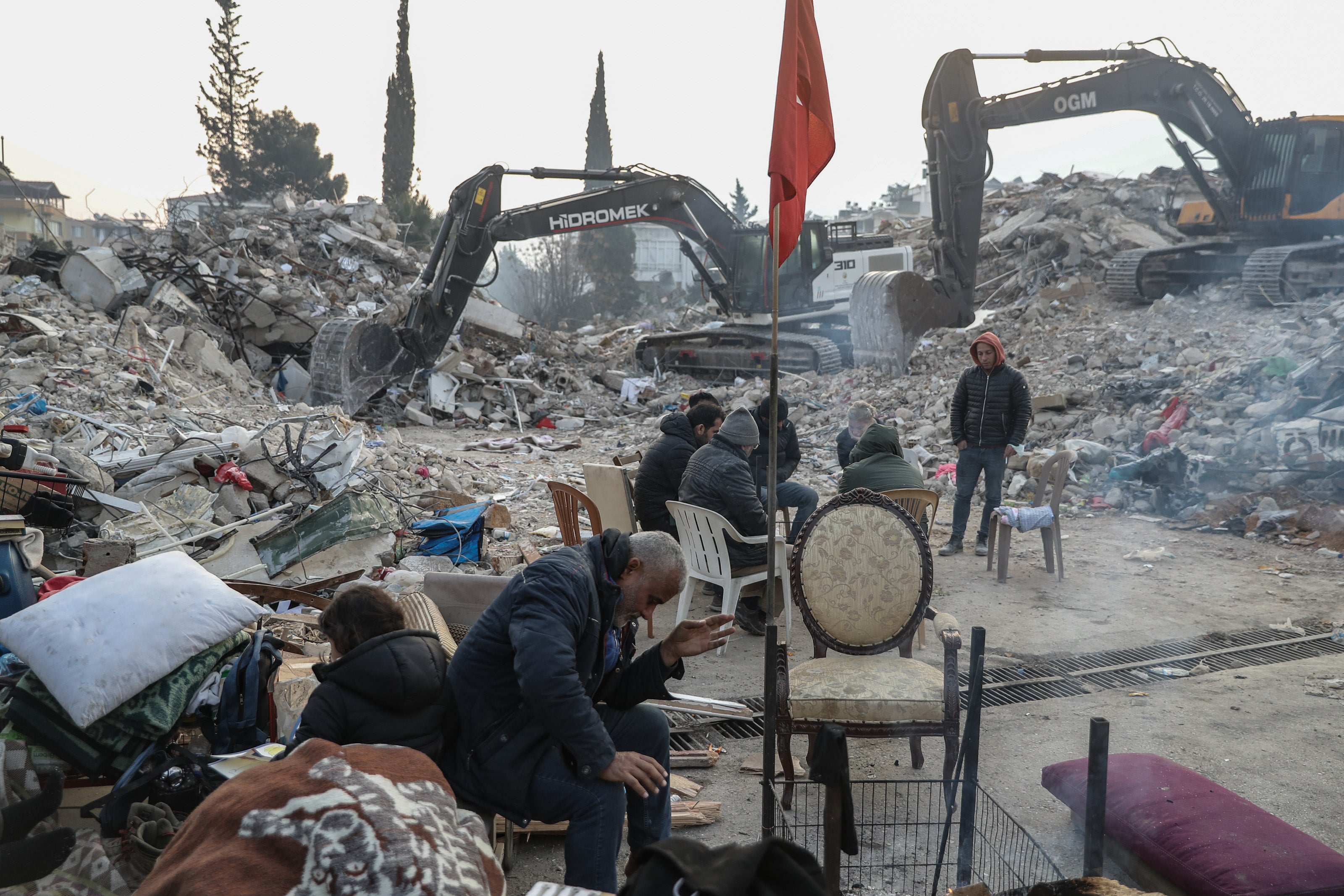 People gather near collapsed buildings in Hatay