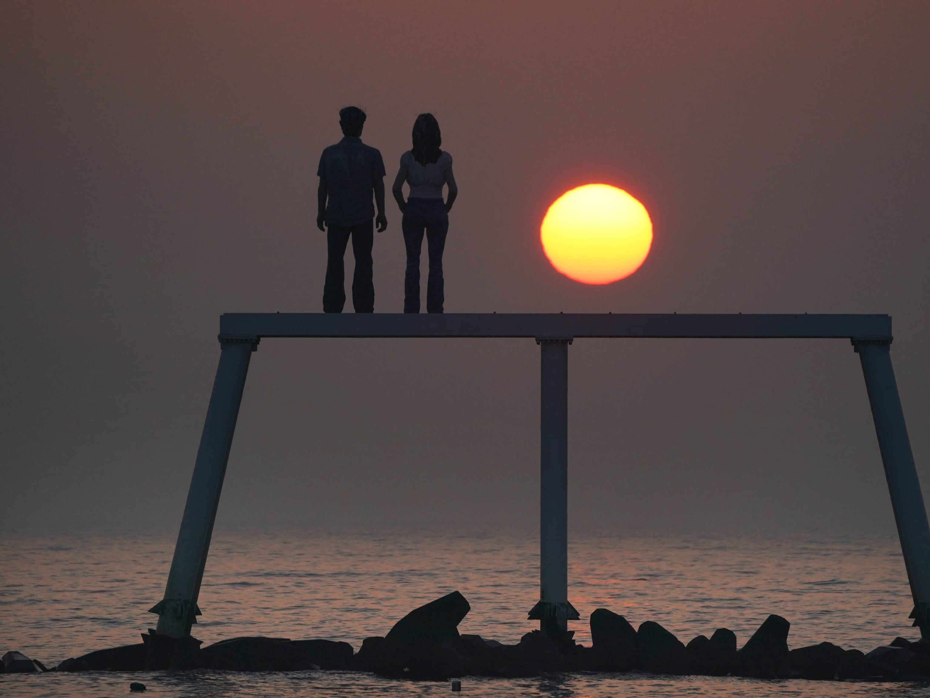 The sunrises through the sea mist over the sculpture “The Couple” by Sean Henry at Newbiggin-by-the-Sea on the Northumberland coast.