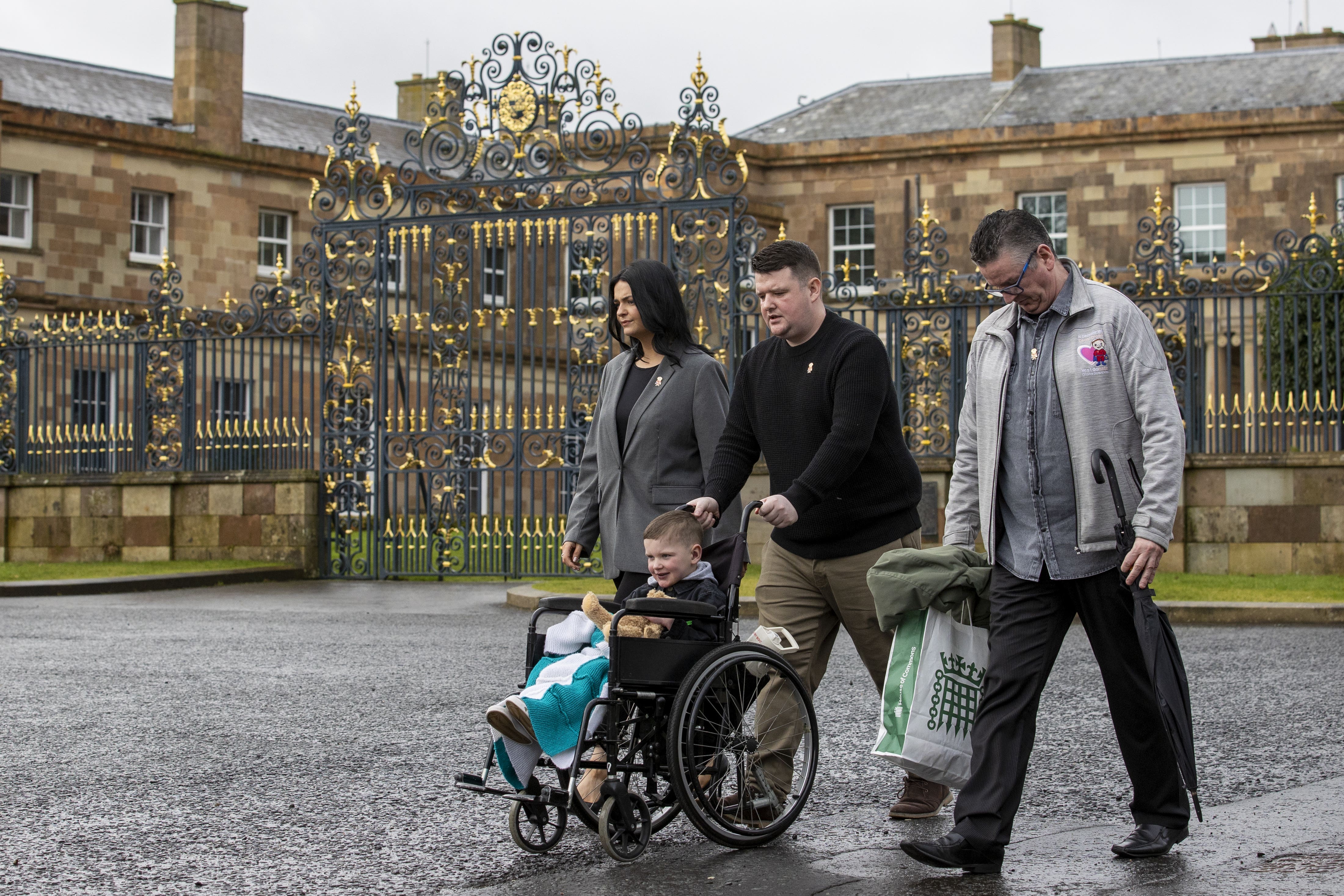 Mairtin MacGabhann and Seph Ni Mheallain with their son Daithi MacGabhann , six, and his grandfather Martin Smith, outside Hillsborough Castle (Liam McBurney/PA)