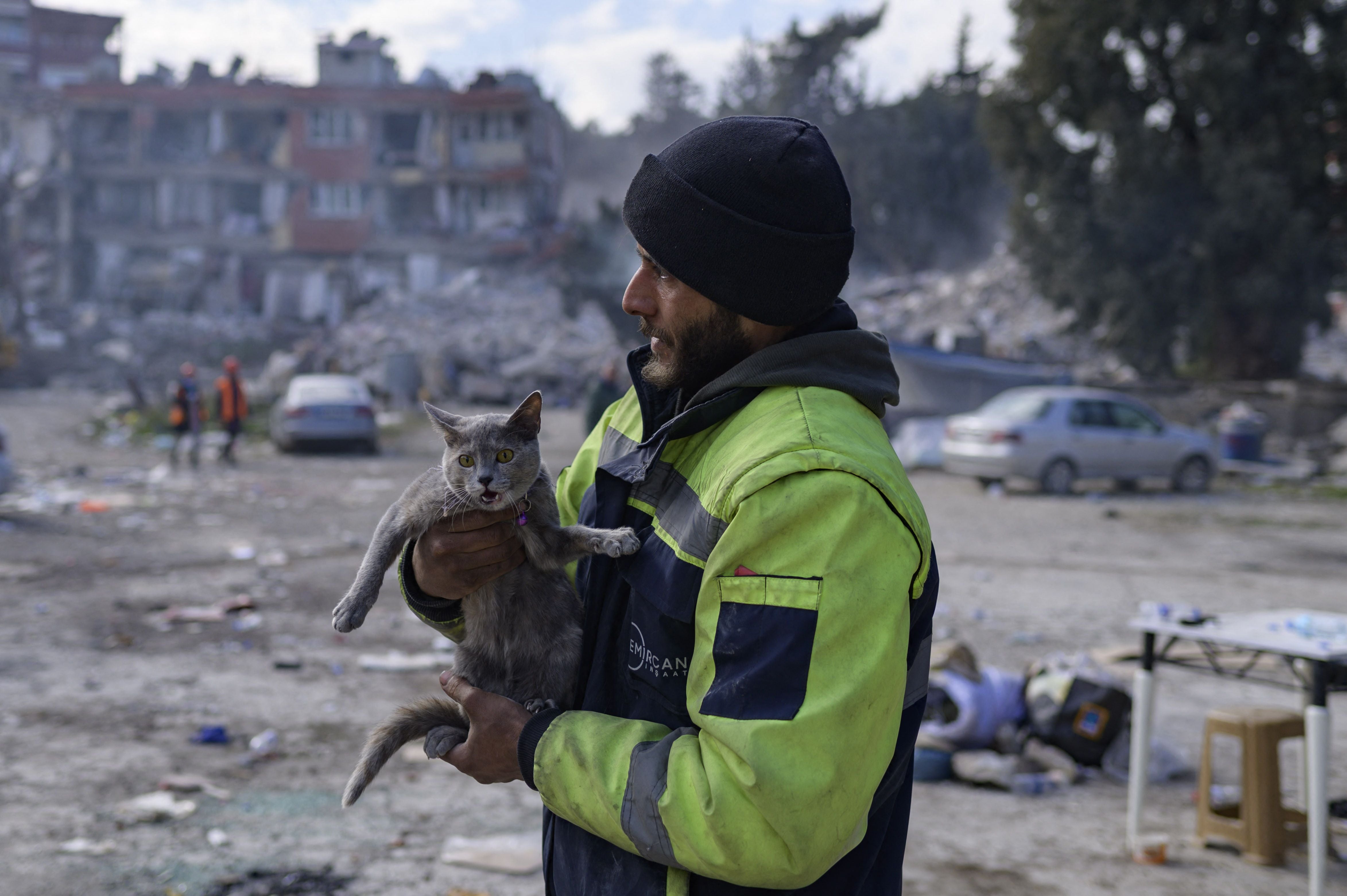 A rescuer holds a cat pulled from a ruined building in Antakya, Turkey on Wednesday