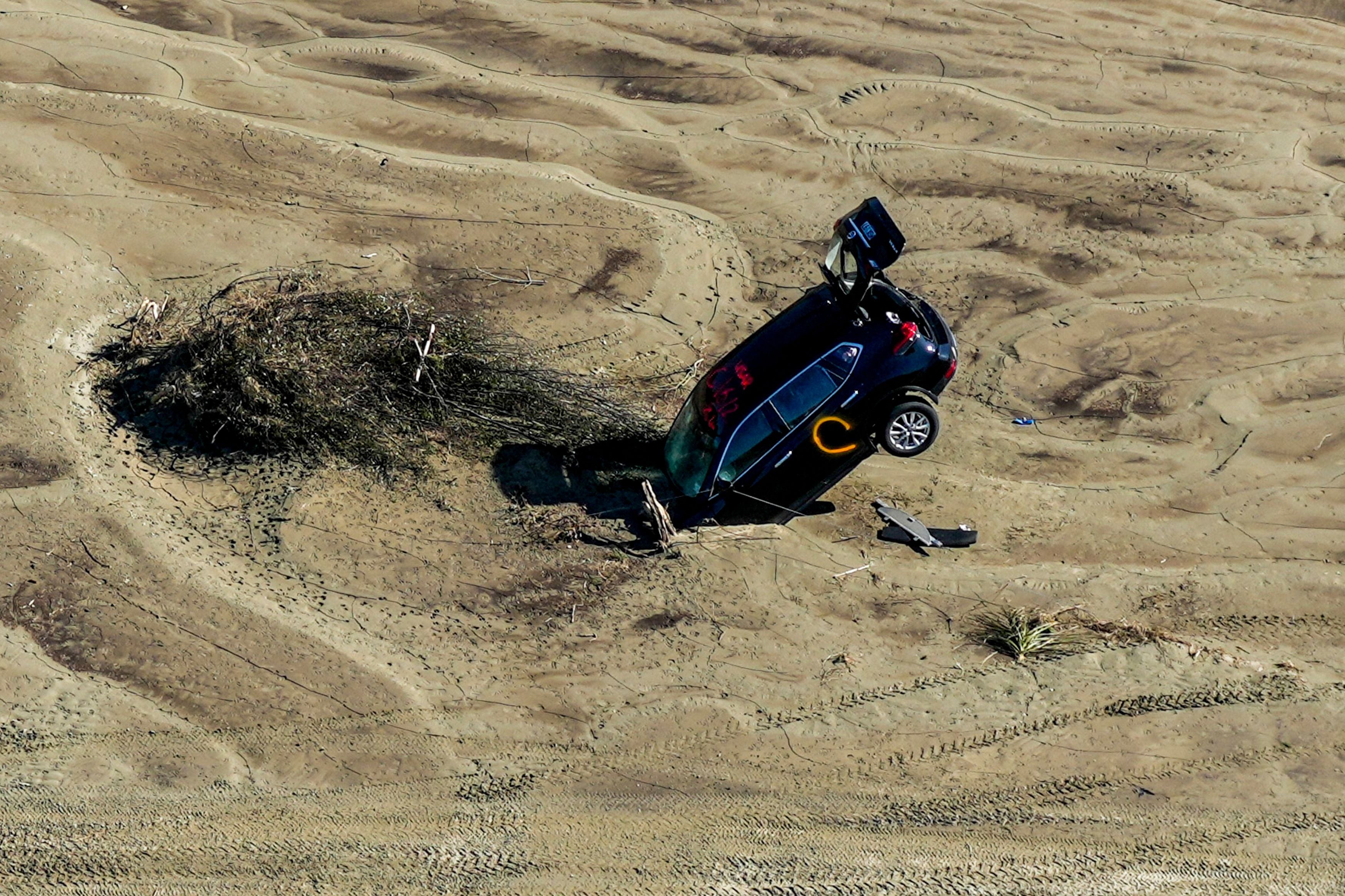 A car stuck in sand is seen in the aftermath of Cyclone Gabrielle in the Esk Valley near Napier on 18 February