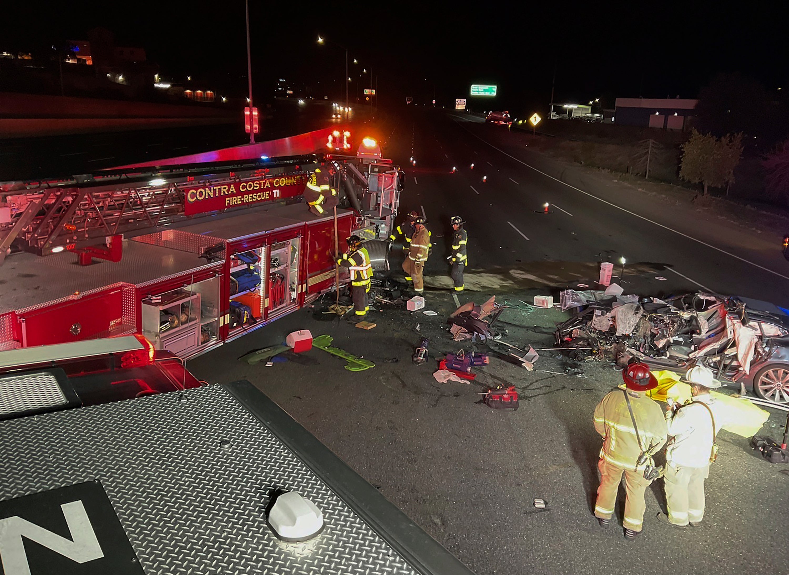 Firefighters work the scene of a fatal accident involving a Tesla and Contra Costa County fire truck