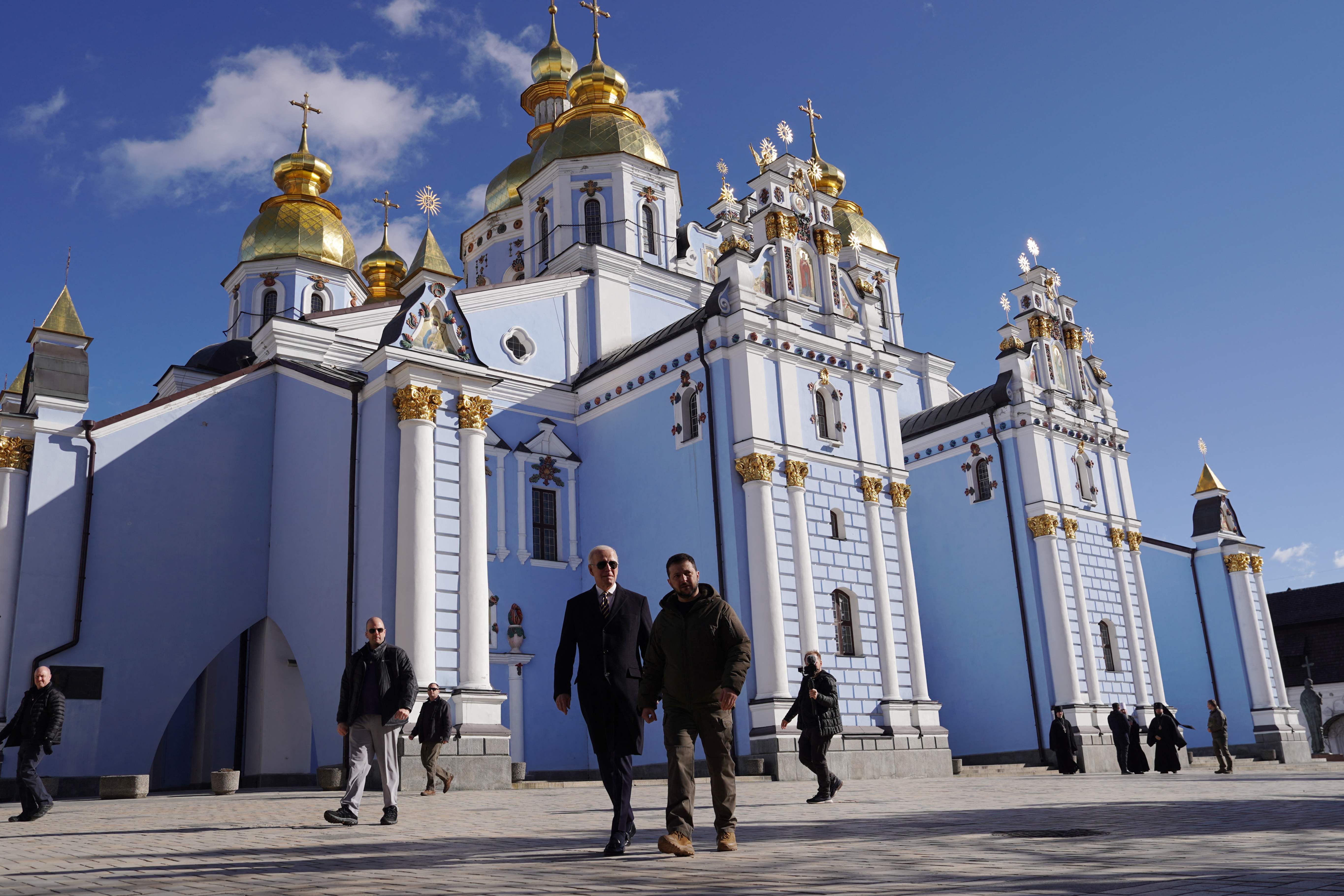 President Joe Biden walks next to Ukrainian President Volodymyr Zelensky in front of St. Michaels Gold-Domed Cathedral