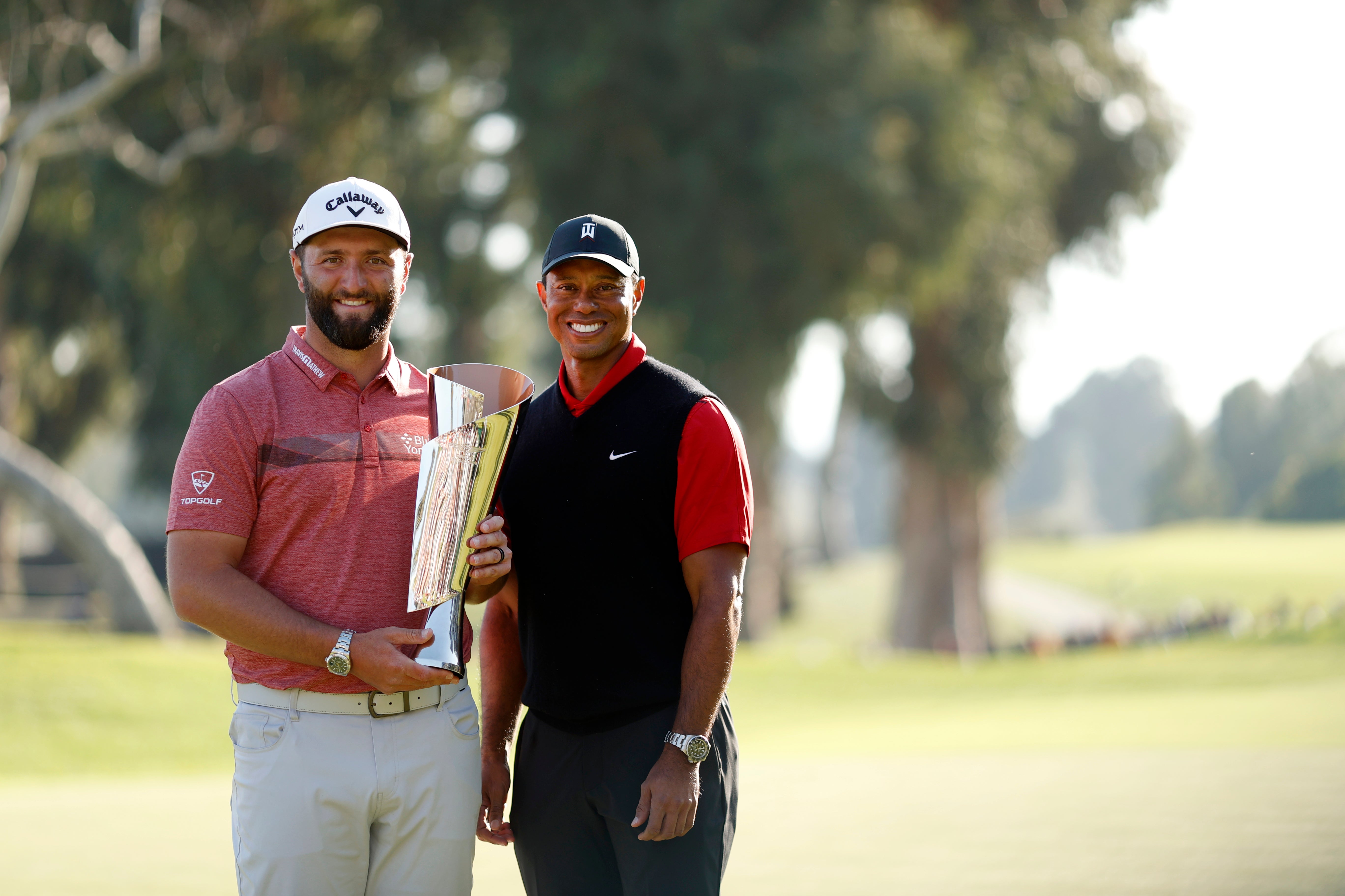 Tiger Woods presents Jon Rahm with the Genesis Invitational trophy