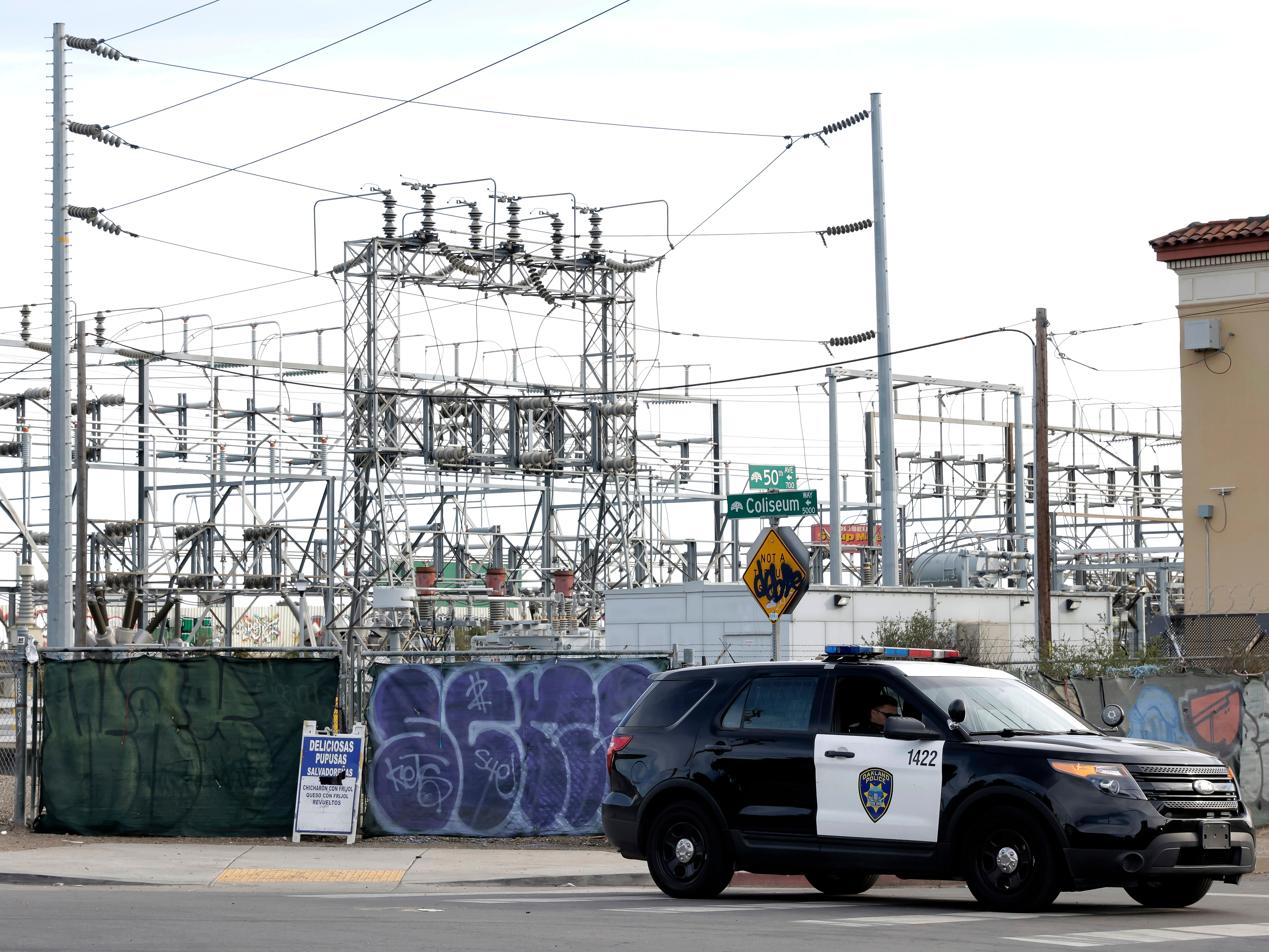 Oakland Police officers block a road near the site of a PG&E substation where a fire earlier in the day caused a power outage throughout much of Oakland, Calif., on Sunday, Feb. 19, 2023. (Carlos Avila Gonzalez/San Francisco Chronicle via AP)