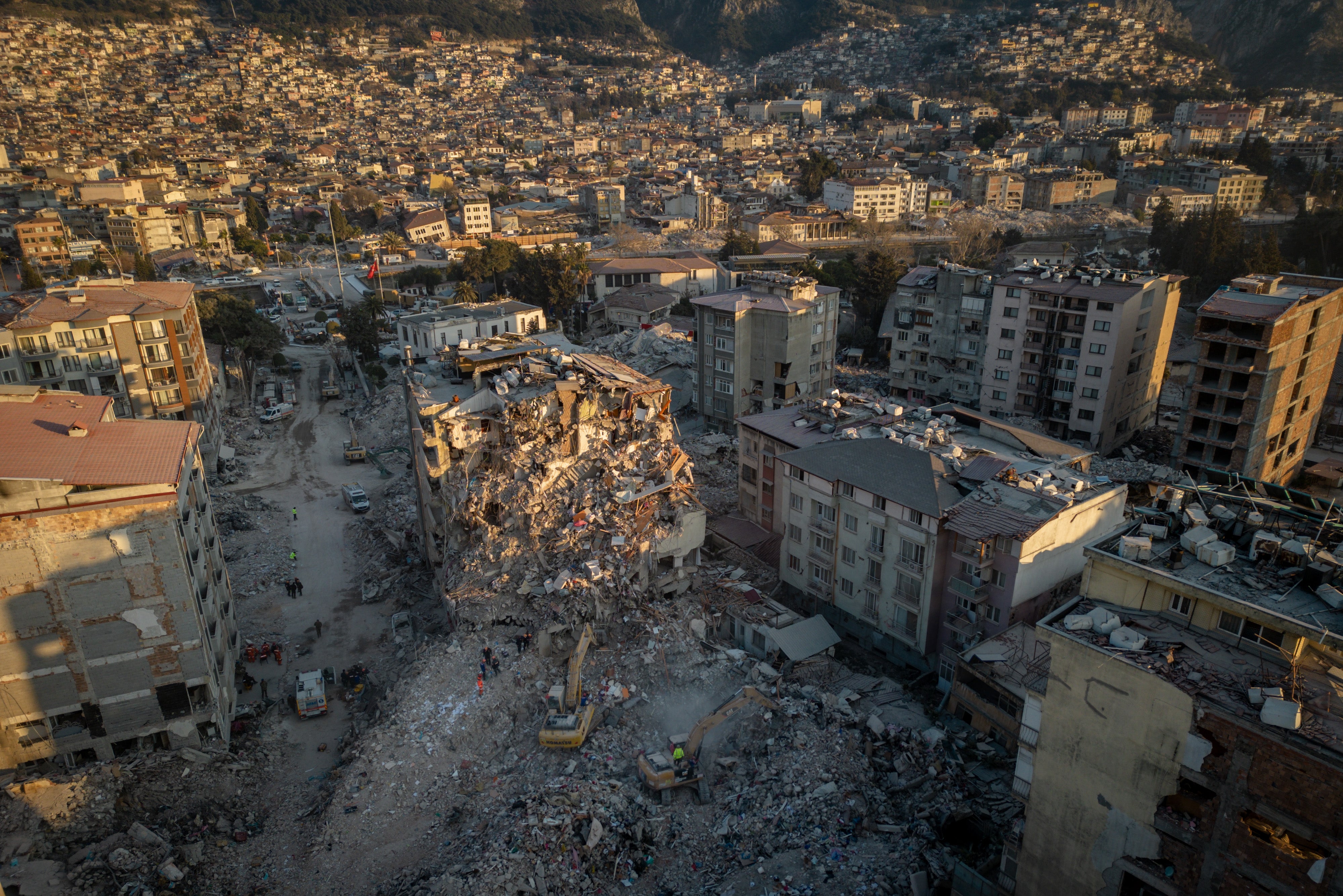 Bulldozers work to clear the rubble of destroyed buildings