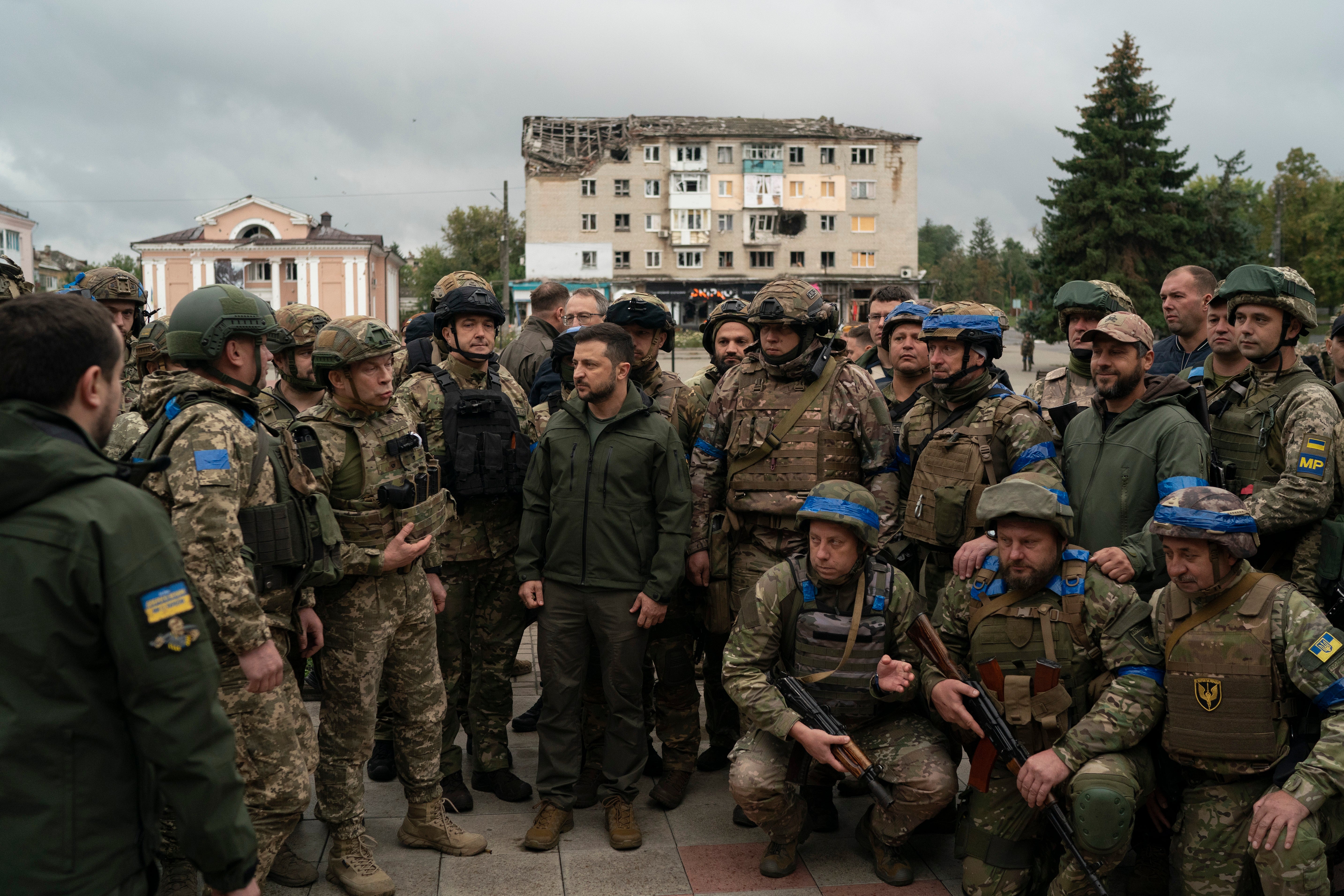 Ukrainian President Volodymyr Zelenskyy stands with soldiers after attending a national flag-raising ceremony in the freed Izium