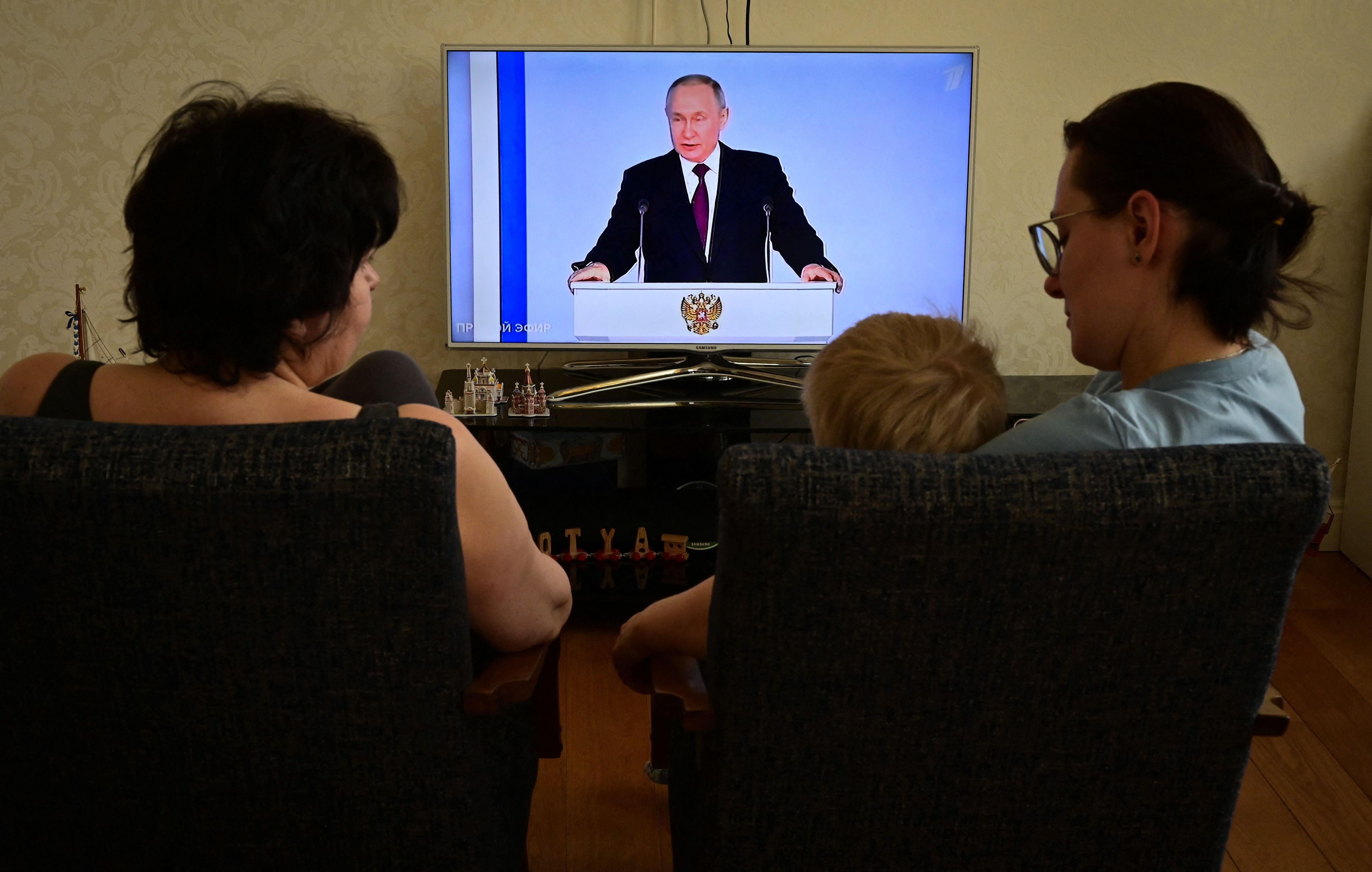 A family watches a TV broadcast of Putin's annual state of the nation address in Moscow last week