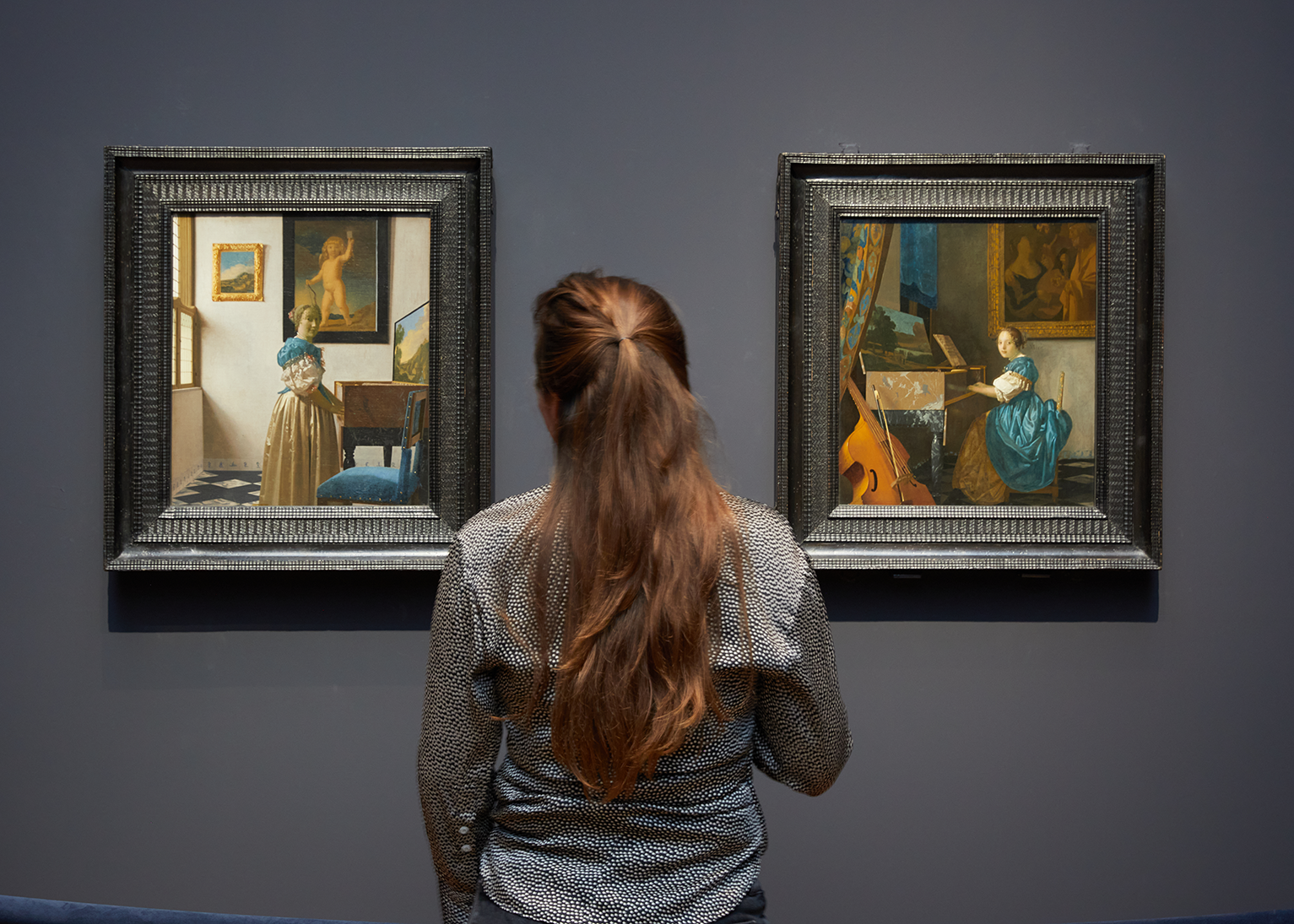 A person looks at artwork included in the Vermeer exhibition at Rijksmuseum