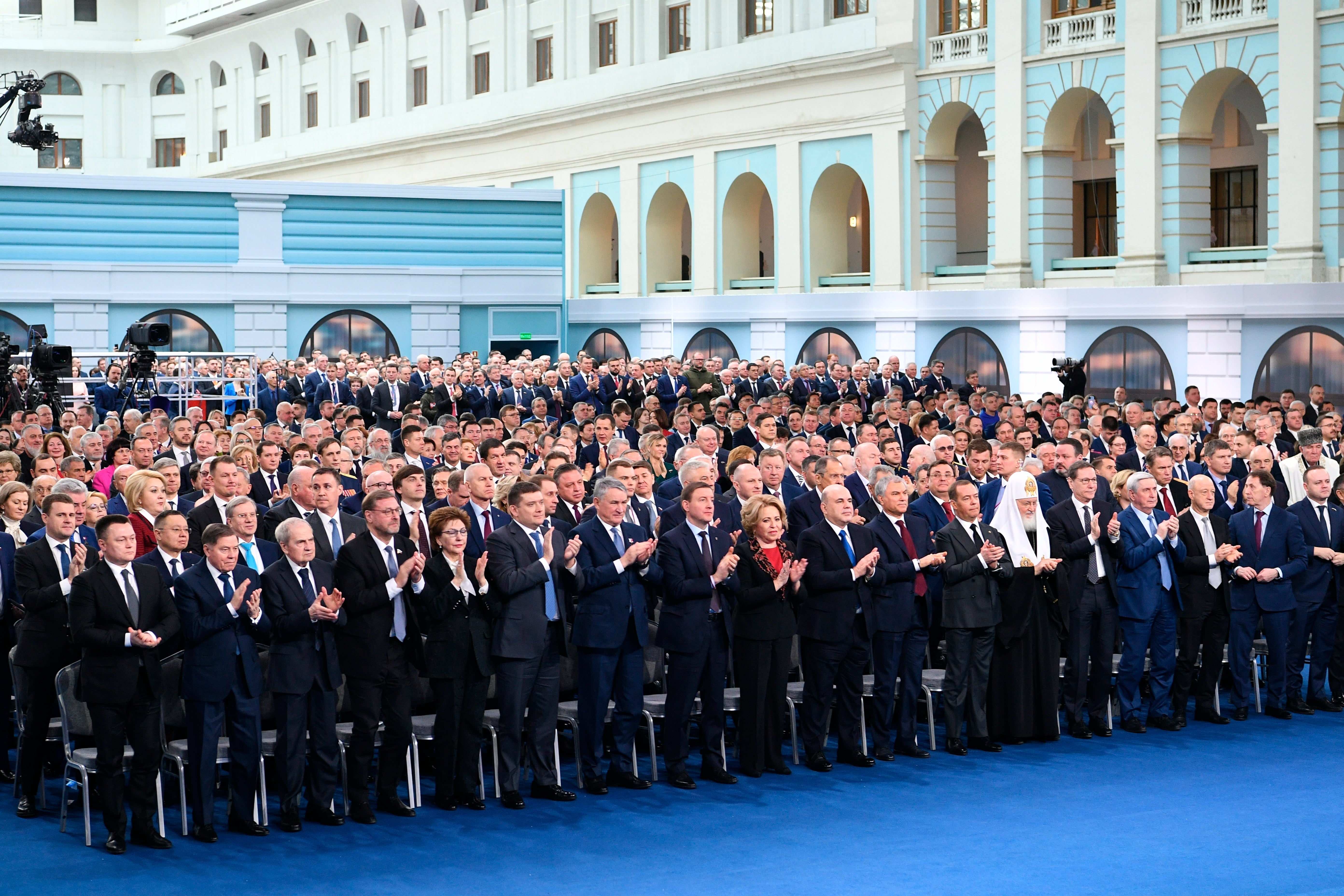 Participants applaud Vladimir Putin after his state of the nation address in Moscow