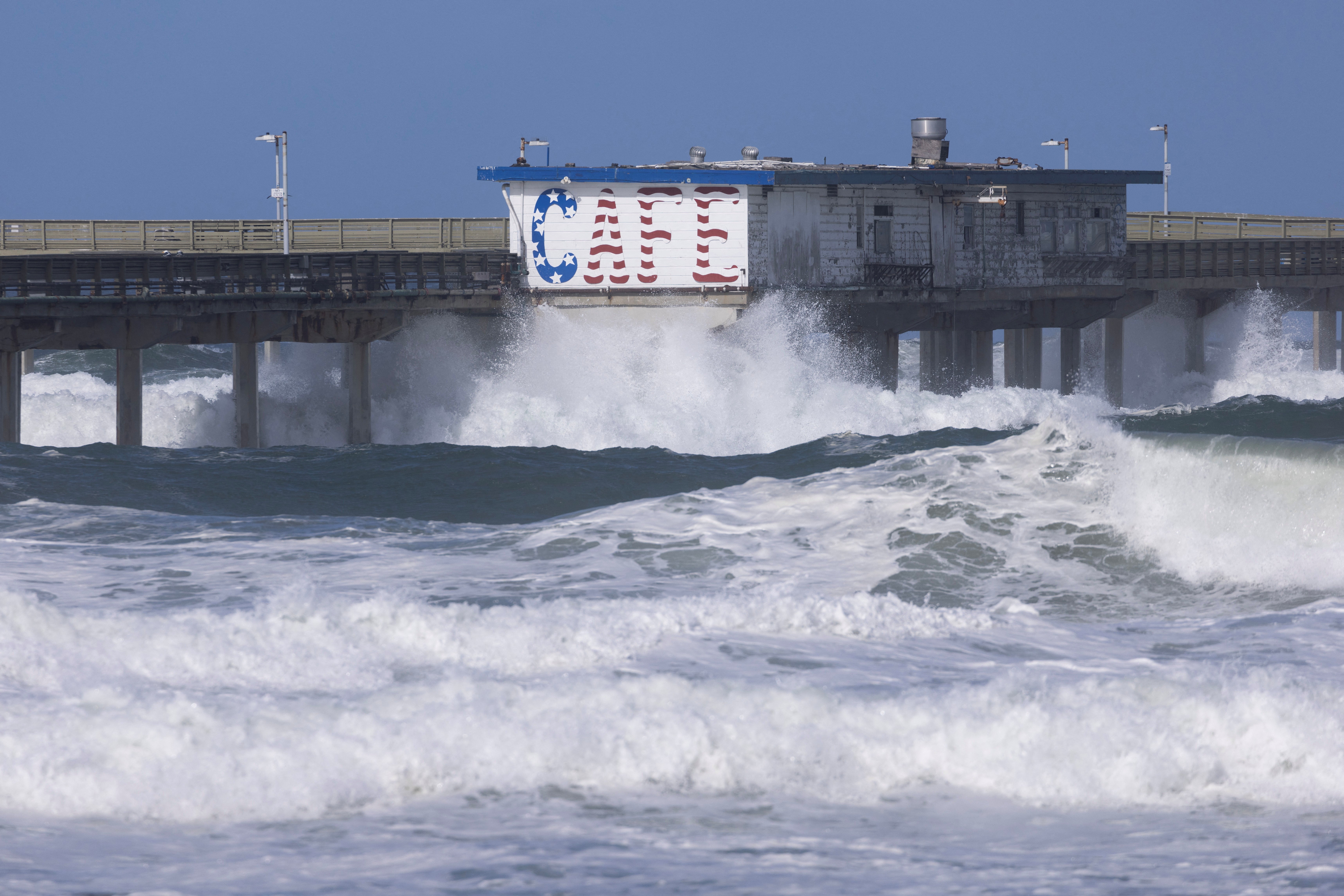 Large waves crash against an ocean pier due to strong winds in the Ocean Beach neighborhood of San Diego, California, February 22, 2023 (REUTERS/Mike Blake)