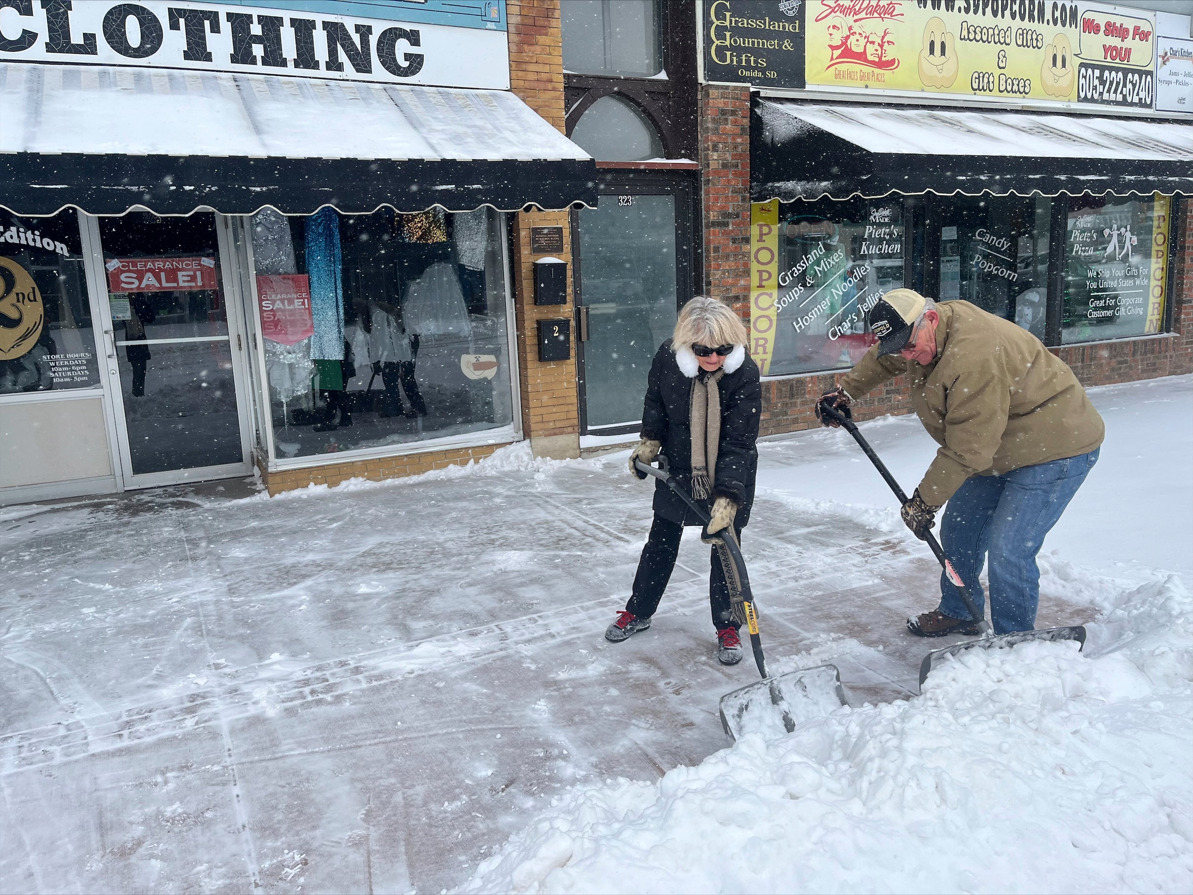 Carolyn and Dan Ellwood shovel snow outside Second Edition in Pierre, South Dakota on Wednesday. Blizzard conditions continued on Thursday with warnings of wind gusts as high as 35mph, and wind chills as low as 30 below zero which could cause frostbite on exposed skin in as little as 10 minutes. (AP Photo/Amancai Biraben)