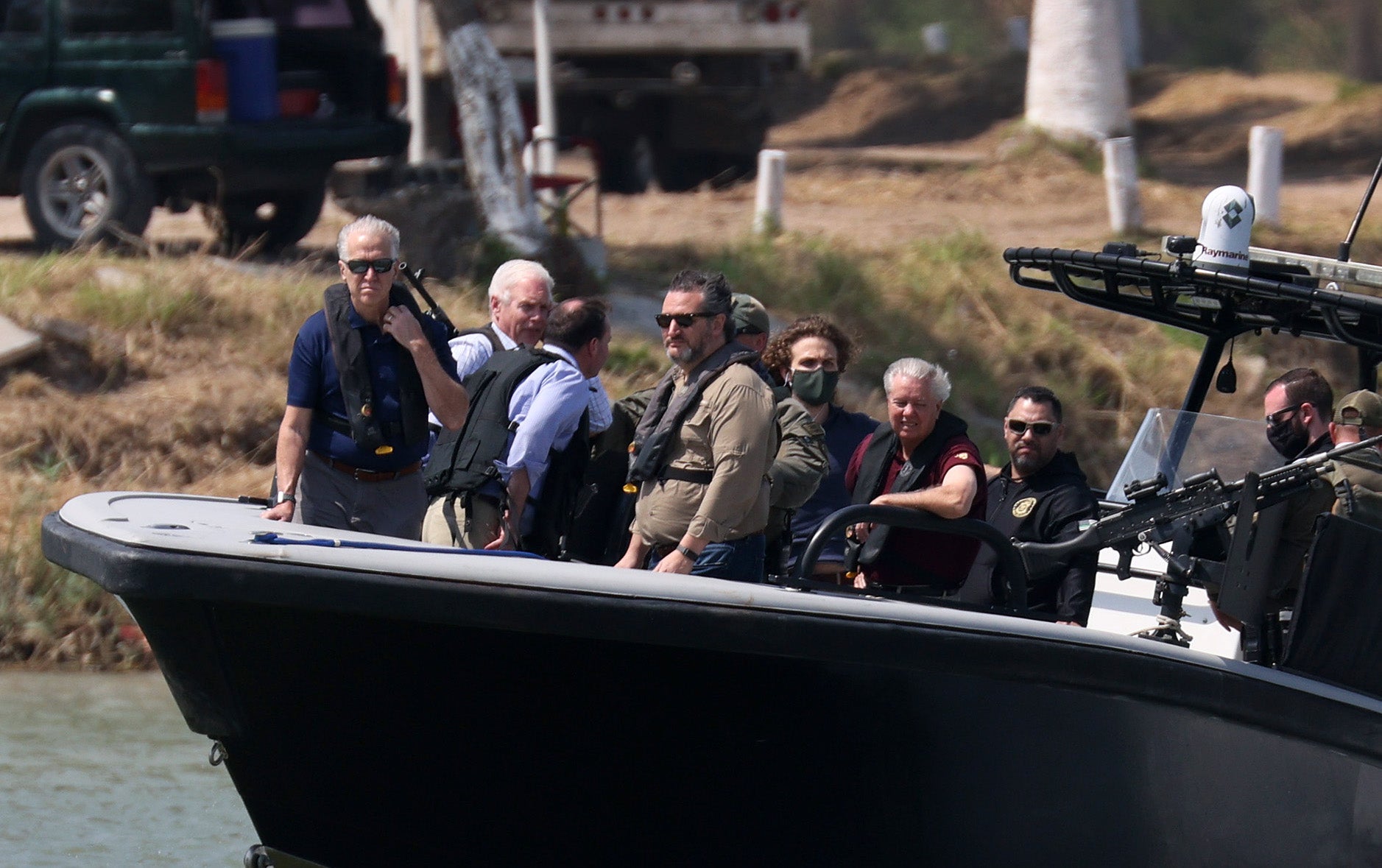 Sen. Ted Cruz (R-TX) and Sen. Lindsey Graham (R-SC) (red shirt) stand aboard a Texas Department of Public Safety boat for a tour of part of the Rio Grande river on March 26, 2021 in Mission, Texas.