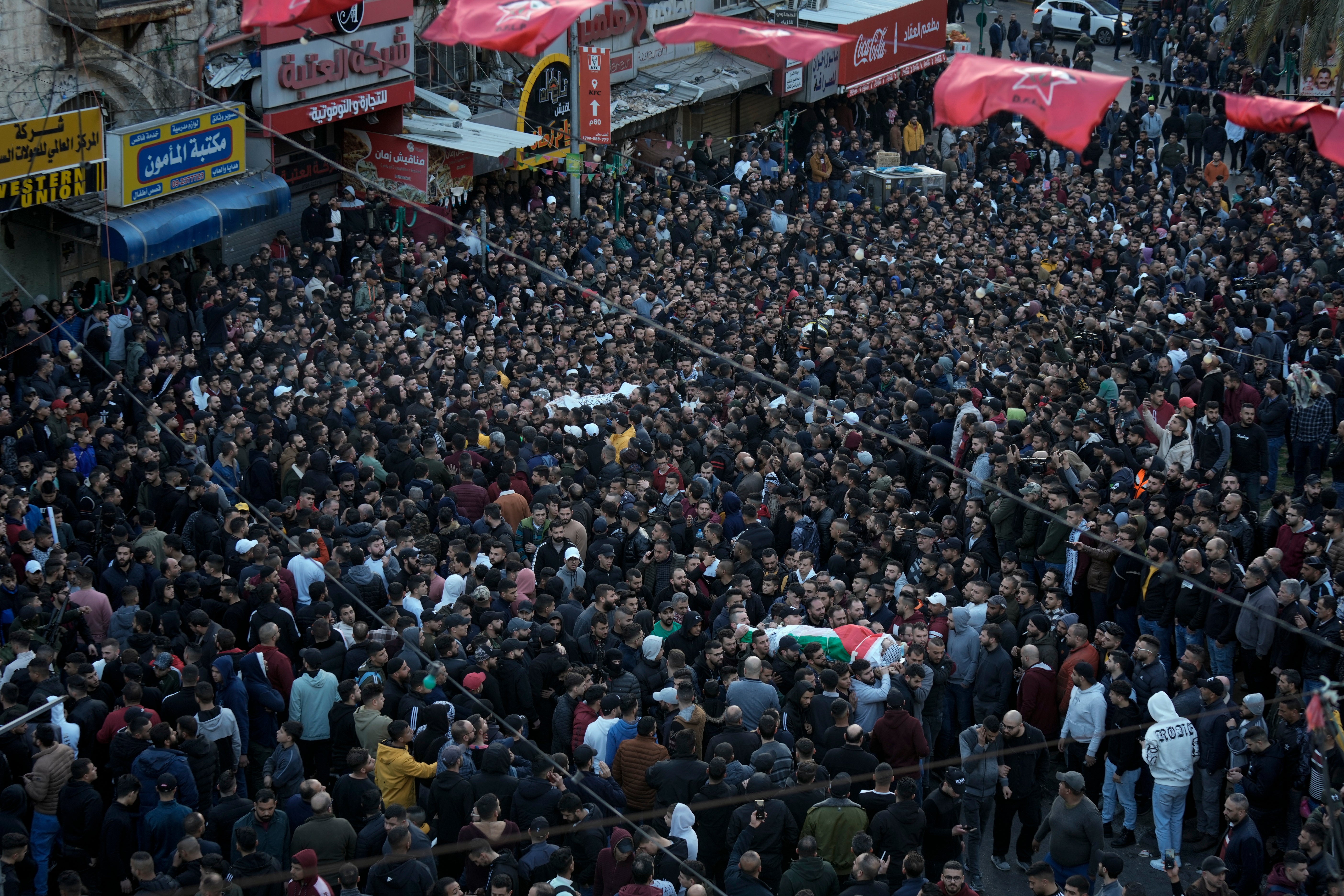 Palestinians carry the bodies of 10 men killed in clashes with Israel troops in the West Bank city of Nablus