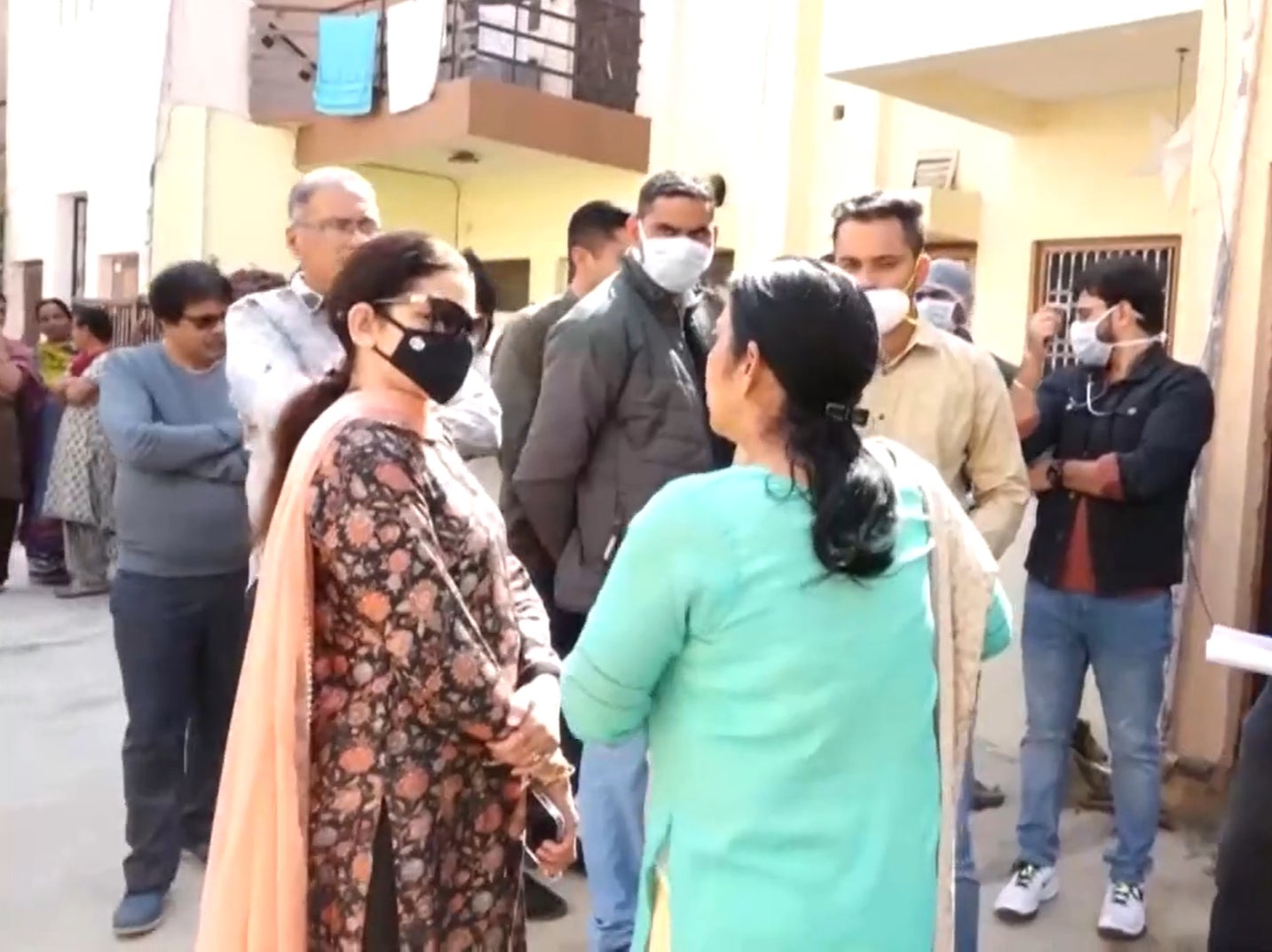 Officials from Child Welfare Committee (CWC) stand in front of the house where woman and child were rescued