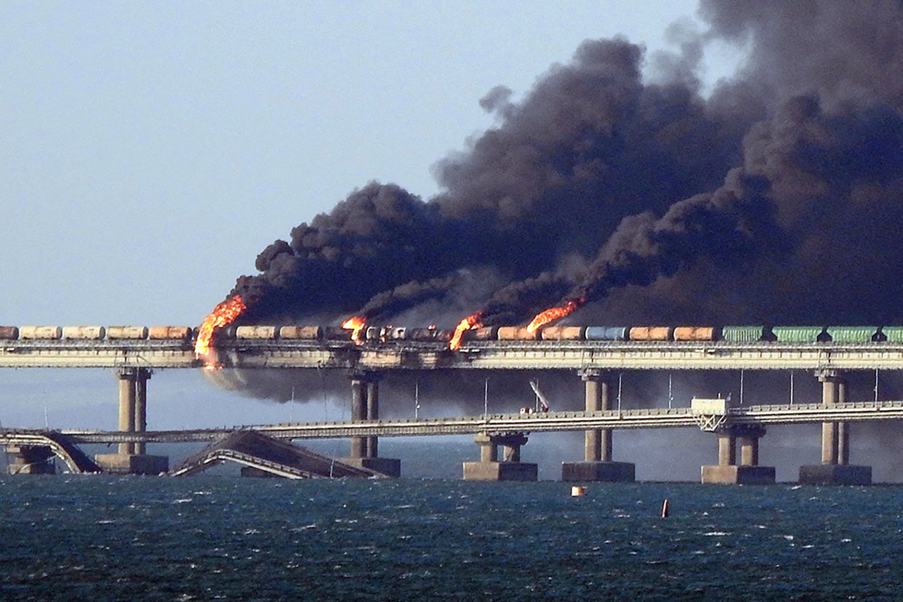 Black smoke billows from a fire on the Kerch bridge that links Crimea to Russia