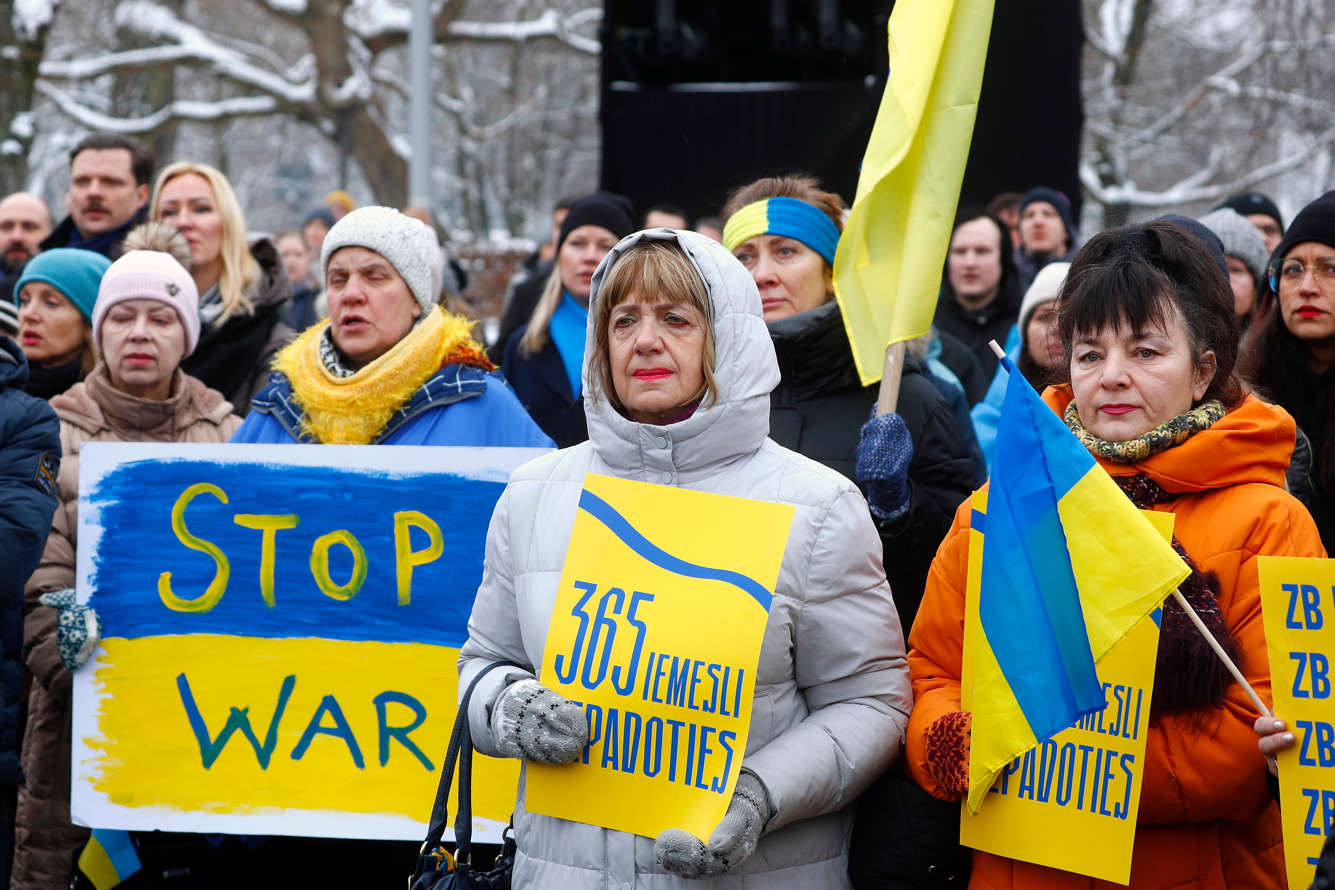 People hold a rally to mark the first anniversary of the Russian invasion of Ukraine at the Freedom Monument in Riga, Latvia