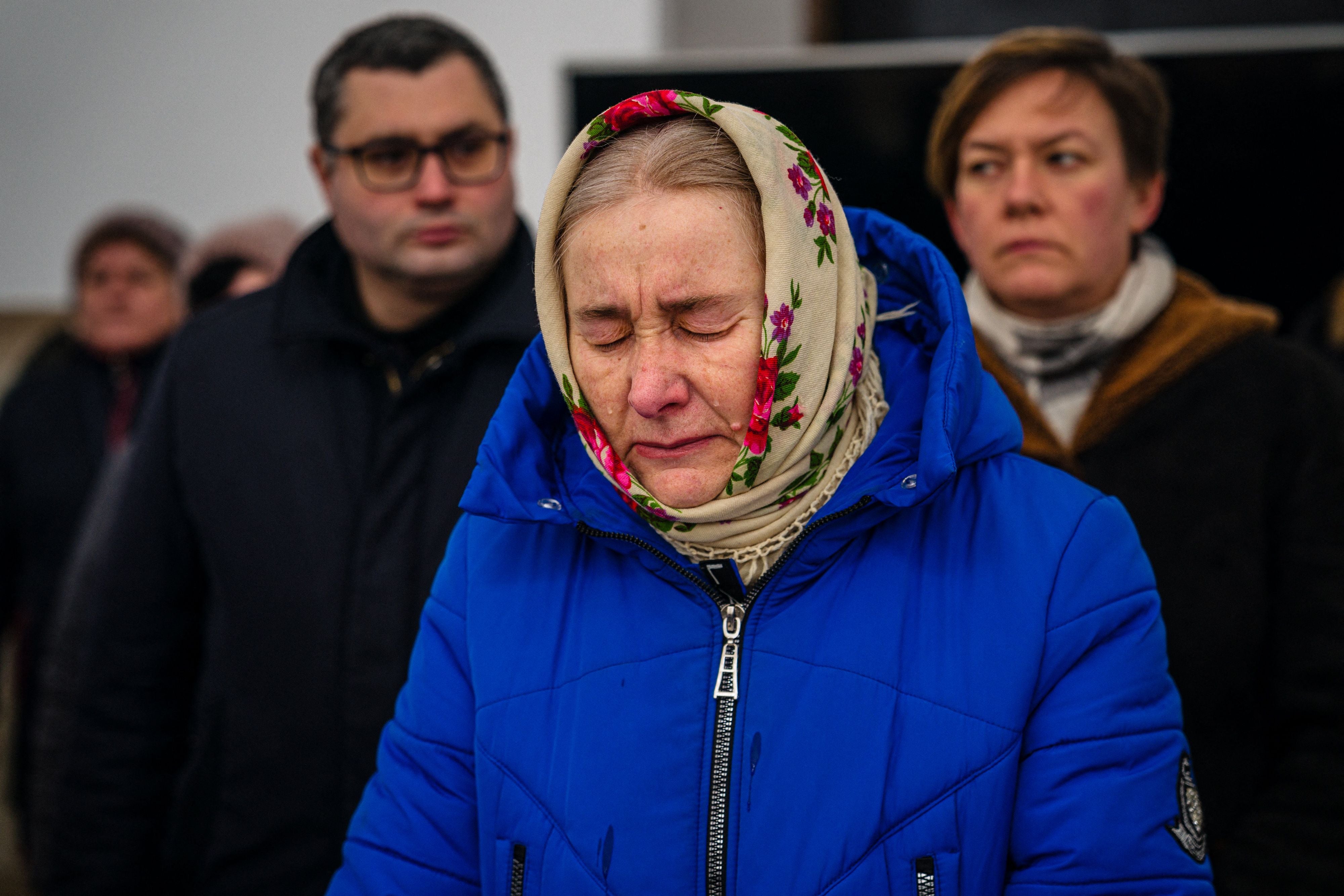 A woman reacts during a prayer service in St Andrew's Church in Bucha, near Kyiv on February 24, 2023, on the first anniversary of the Russian invasion of Ukraine