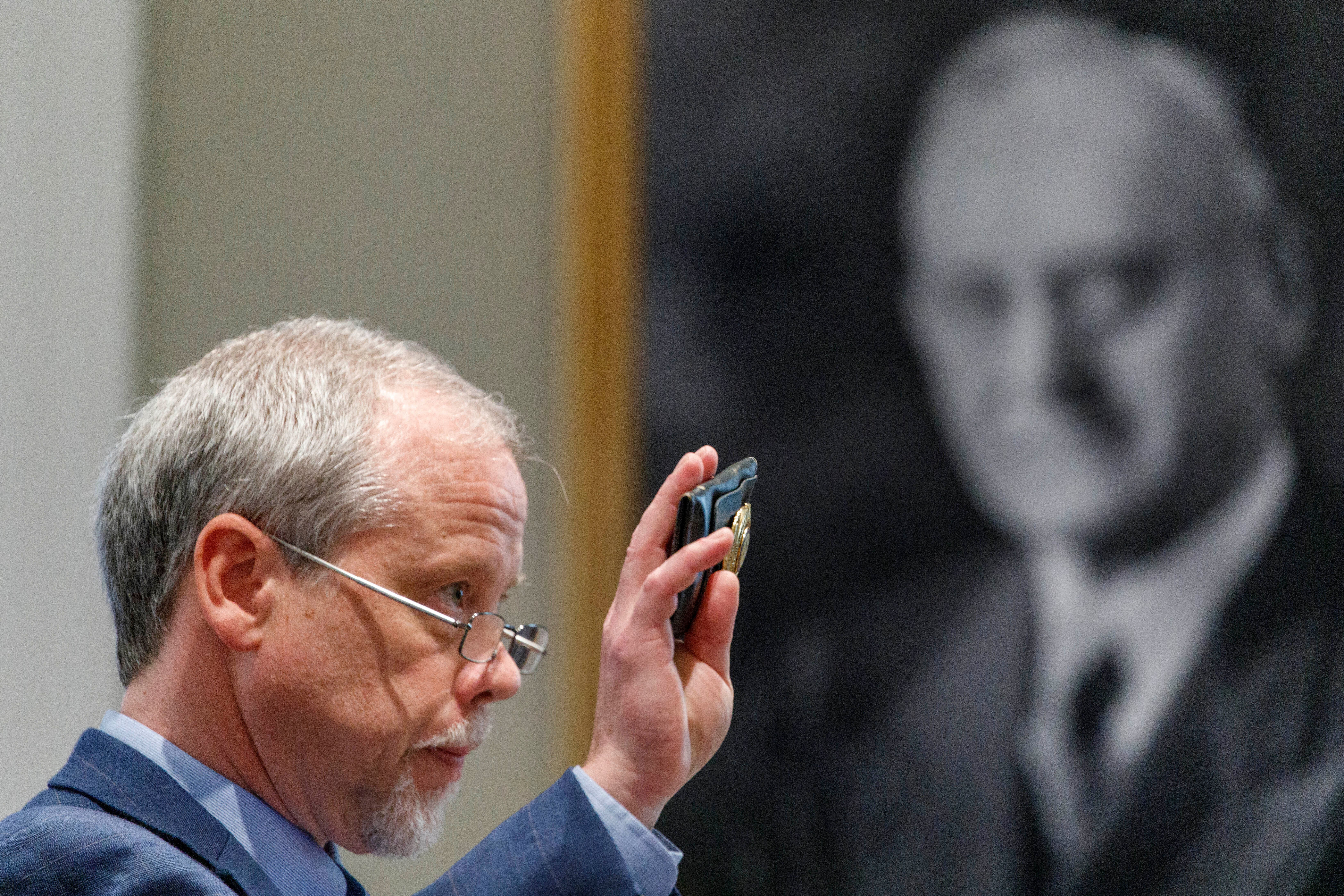 Prosecutor Creighton Waters holds up a 14th circuit solicitors badge of Alex Murdaugh’s