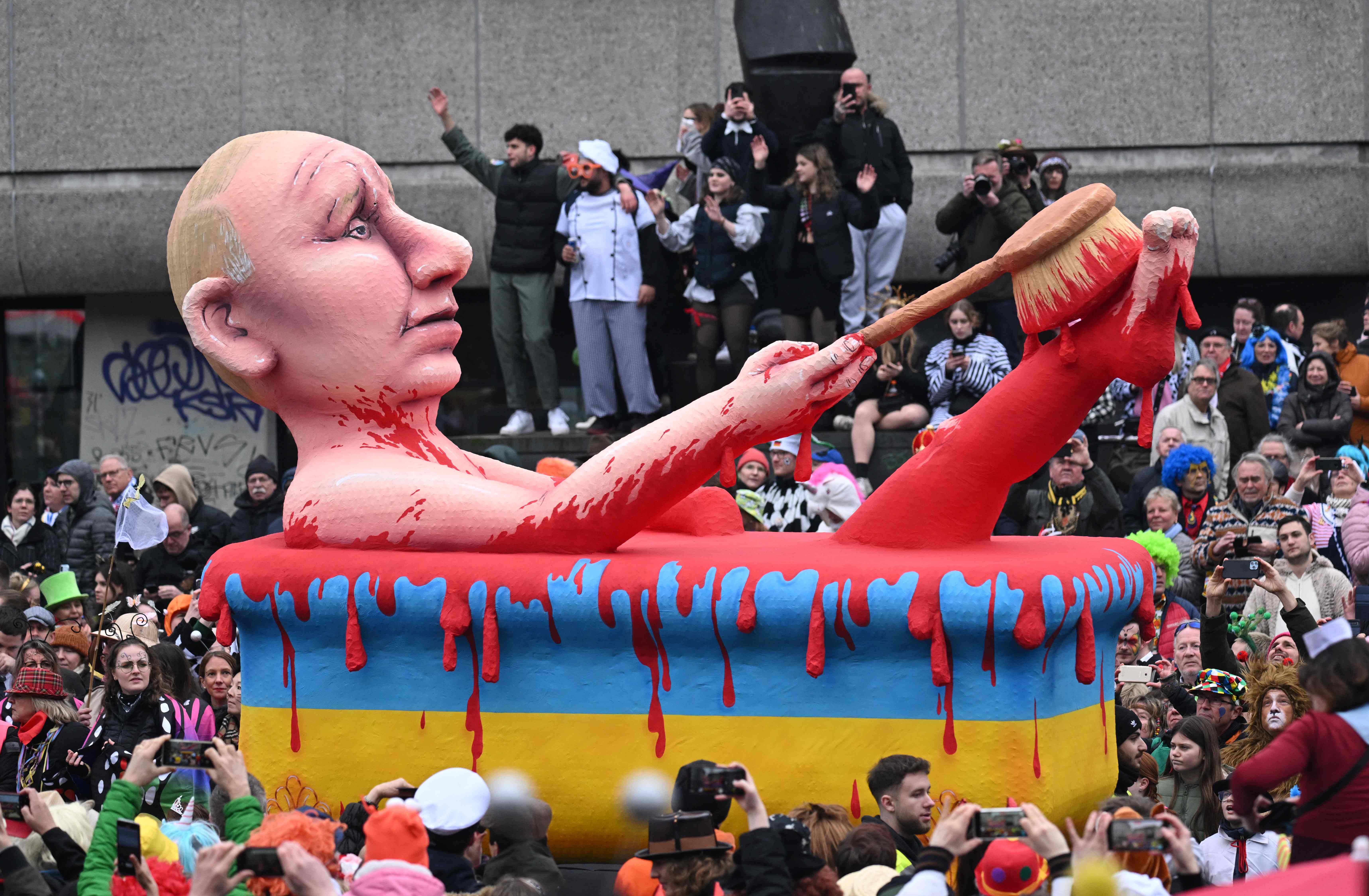 A carnival float featuring Russia's President Vladimir Putin taking a blood bath in a yellow-blue bathtub is pictured during a Rose Monday street carnival parade in Duesseldorf, western Germany