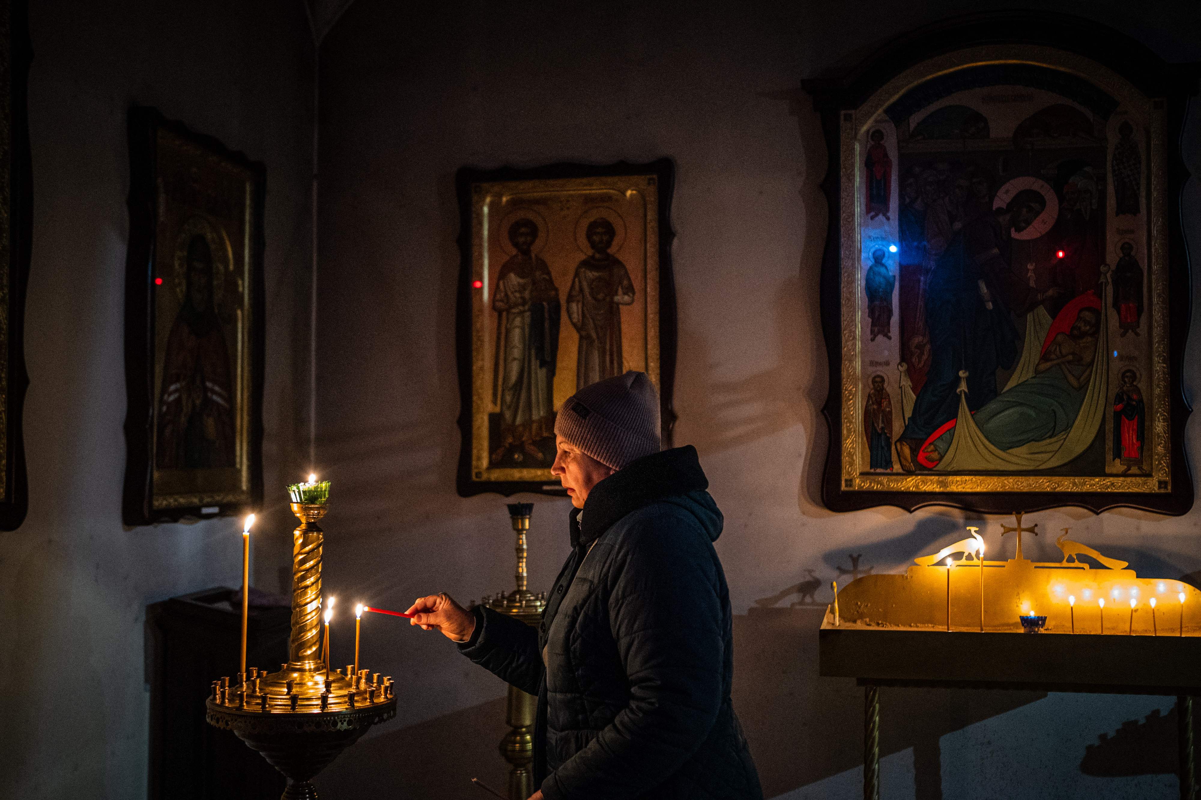 A woman lights a candle in St Andrew’s Church in Bucha, near Kyiv on Friday