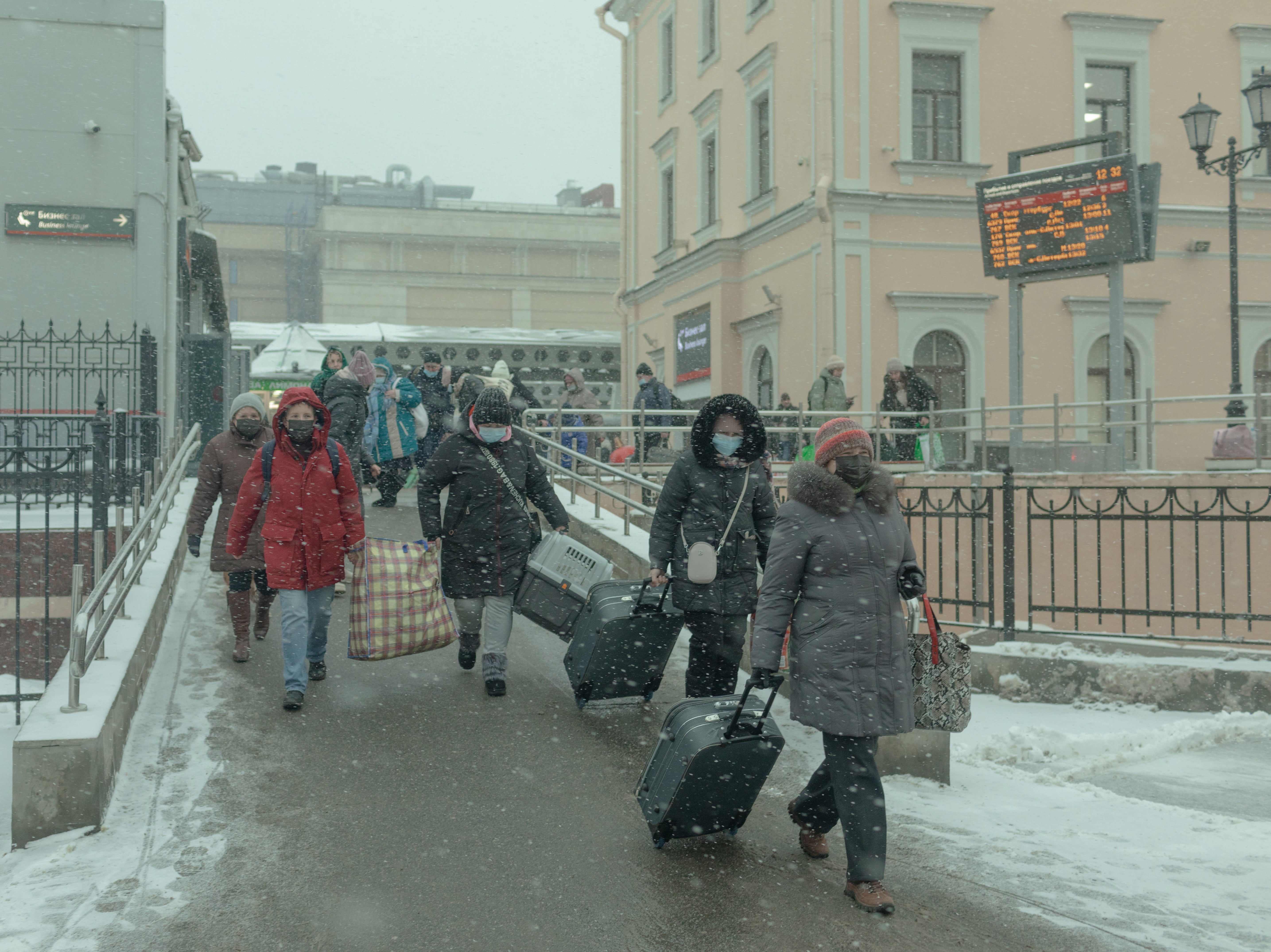 Volunteers help carry items for a family of Ukrainian refugees outside the Moskovsky railway station in St Petersburg