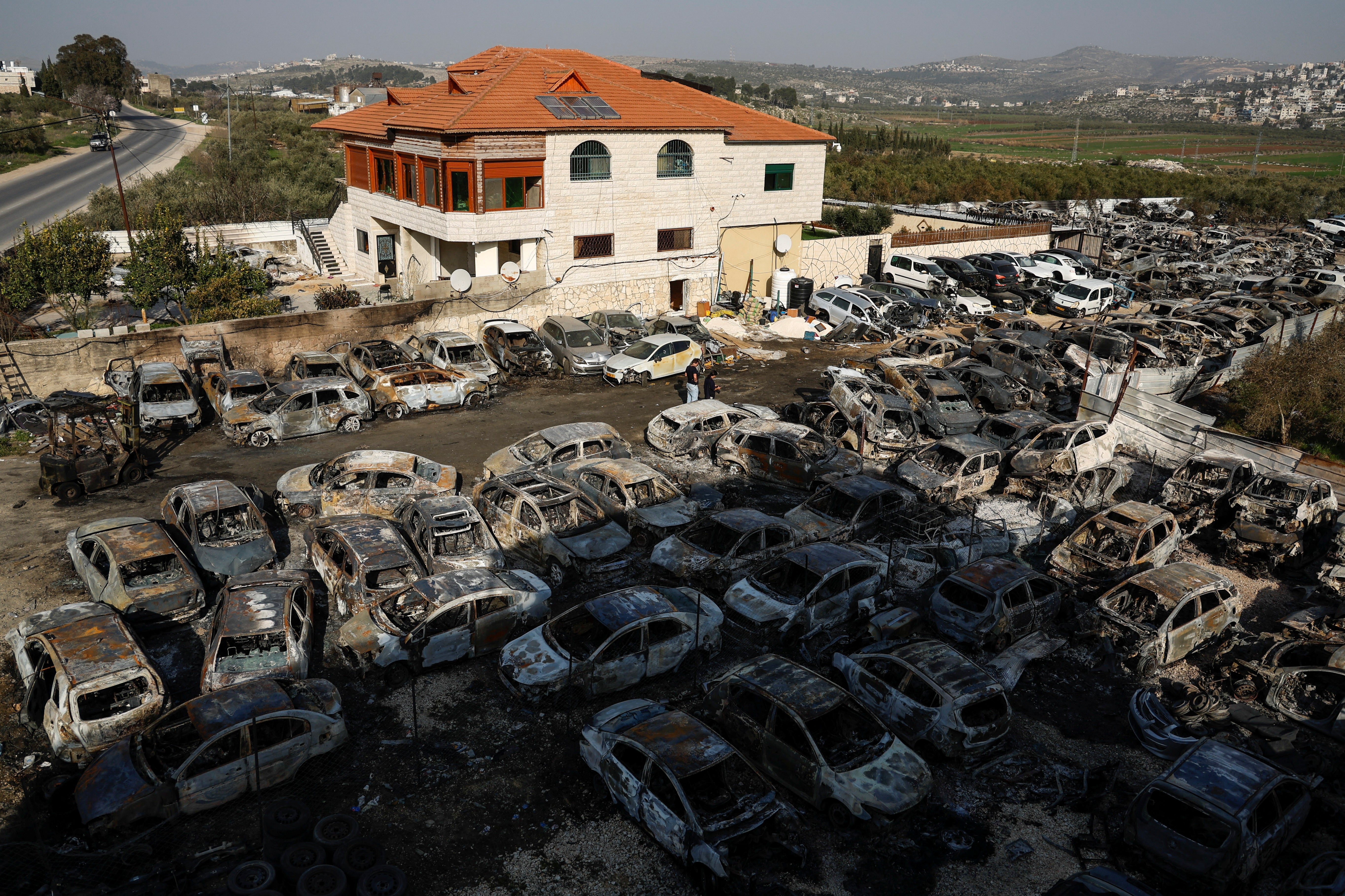 Cars burnt in an attack by Israeli settlers, following an incident where a Palestinian gunman killed two Israeli settlers