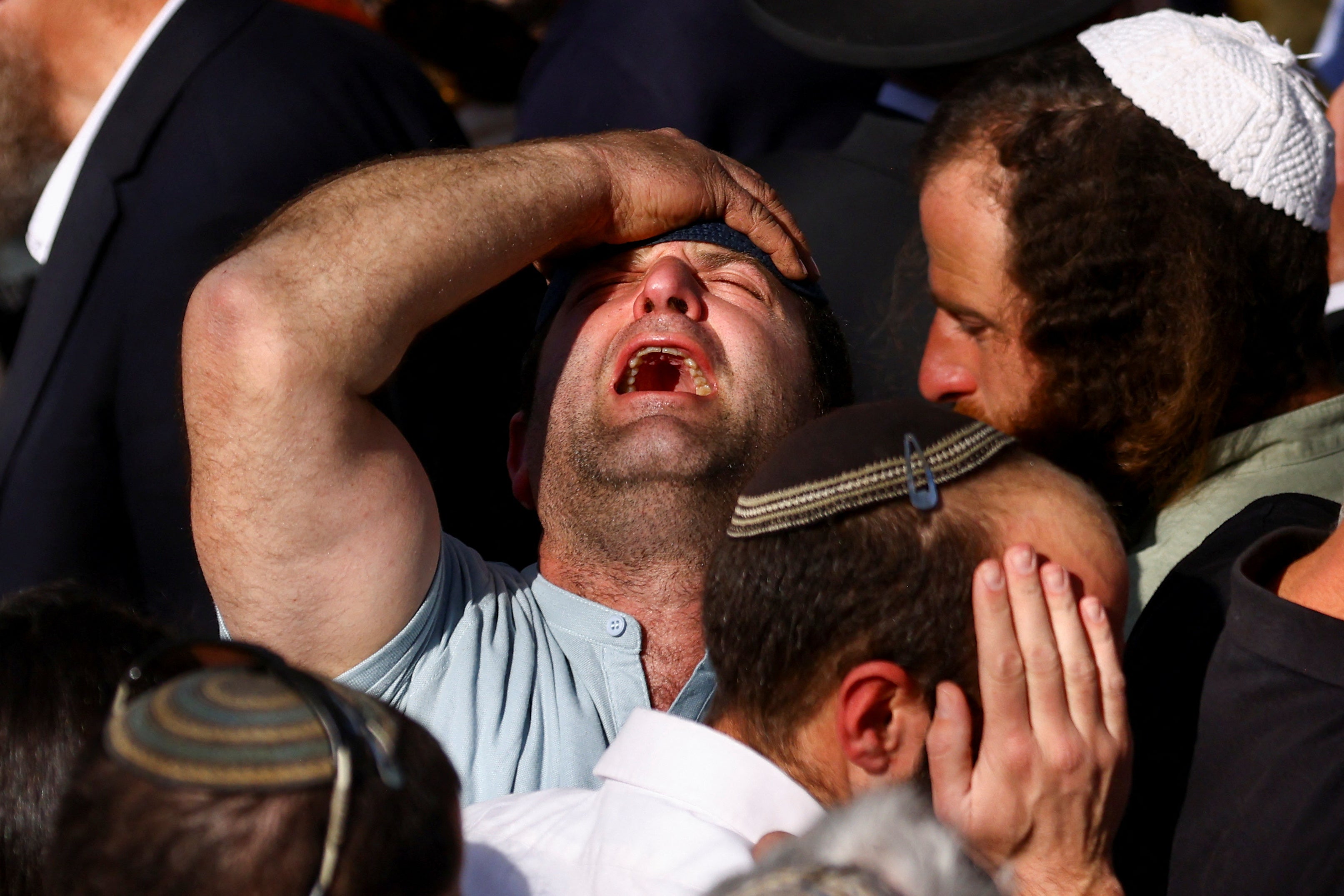 A mourner reacts during the funeral of Hillel Yaniv and Yigal Yaniv, Israeli brothers from the Har Bracha settlement