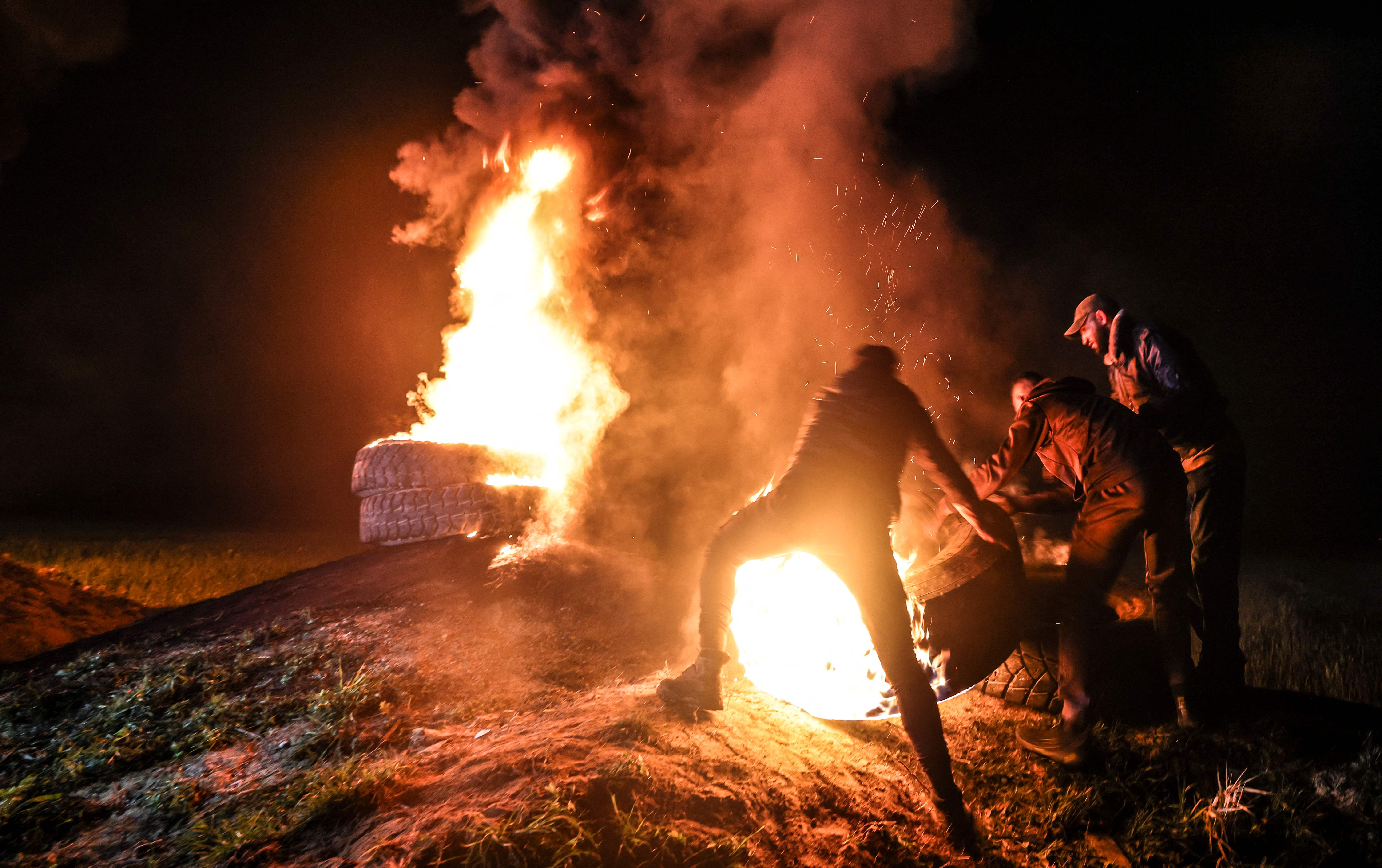 Palestinian youths burn tires during a protest near the Israel-Gaza border, East of Gaza City