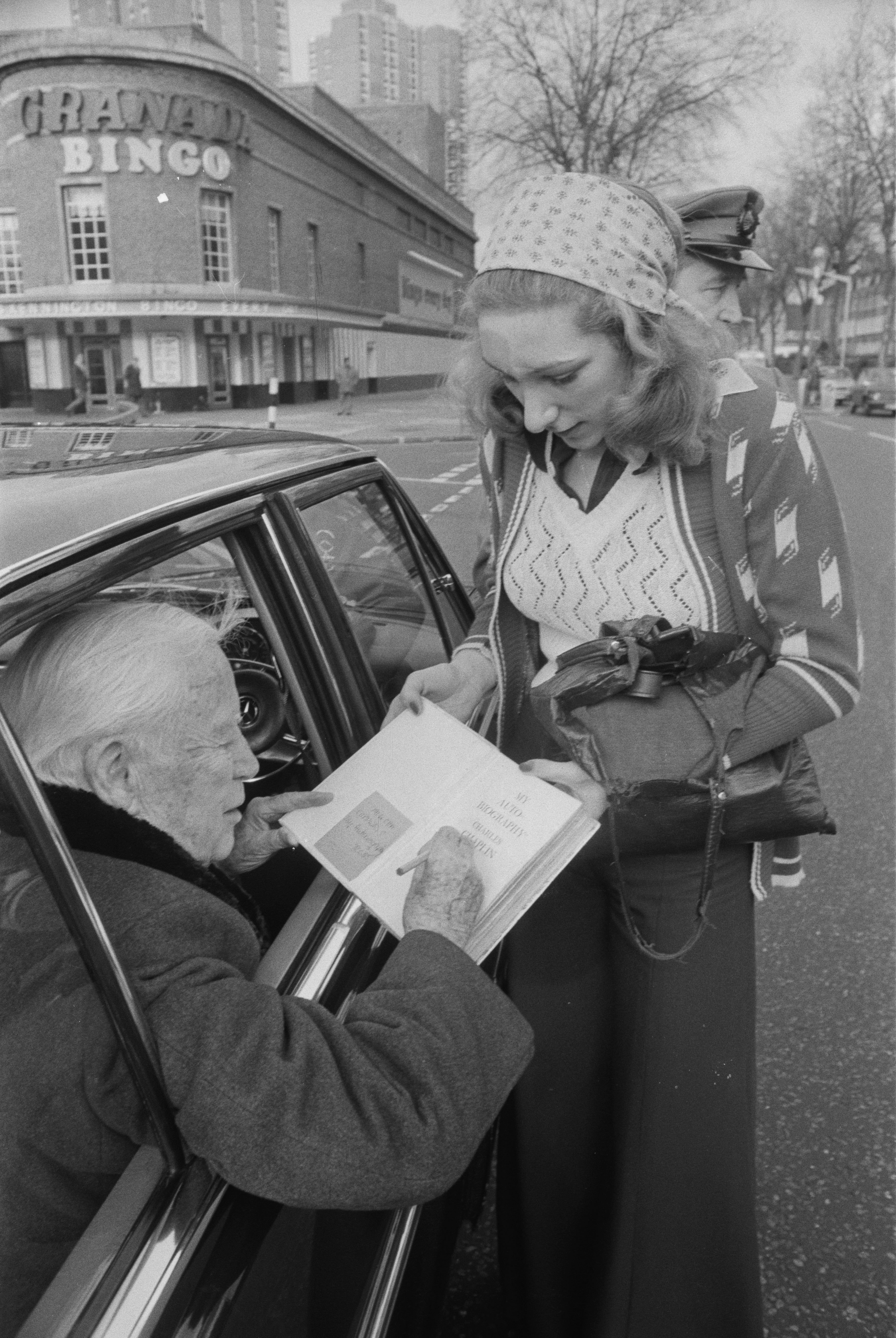 Charlie Chaplin signs a copy of his autobiography for a fan on 13 January 1975