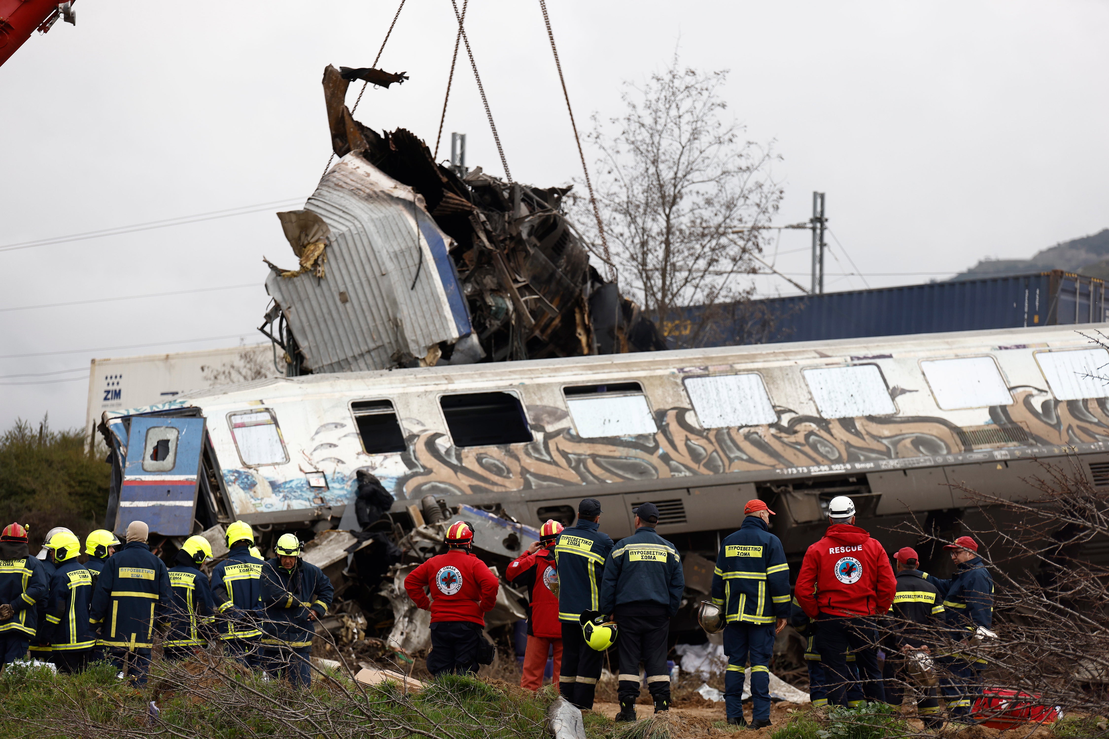 Crane vehicles try to remove pieces of damaged train wagon after a collision near Larissa city, Greece