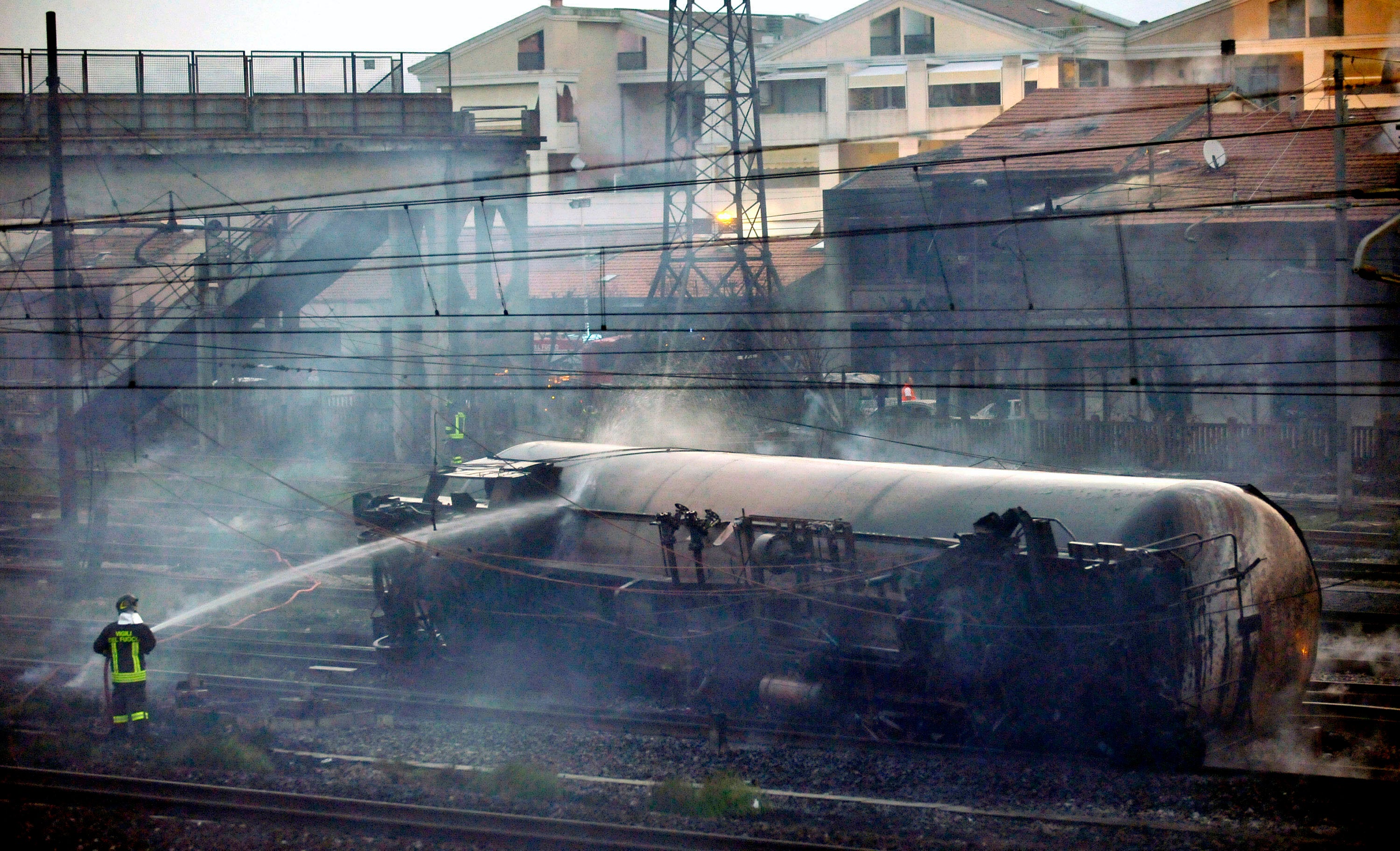 A fireman sprays water on the wrecked car of a freight train in Viareggio, on 30 June, 2009, after it exploded just outside the station of this coastal town in northern Italy