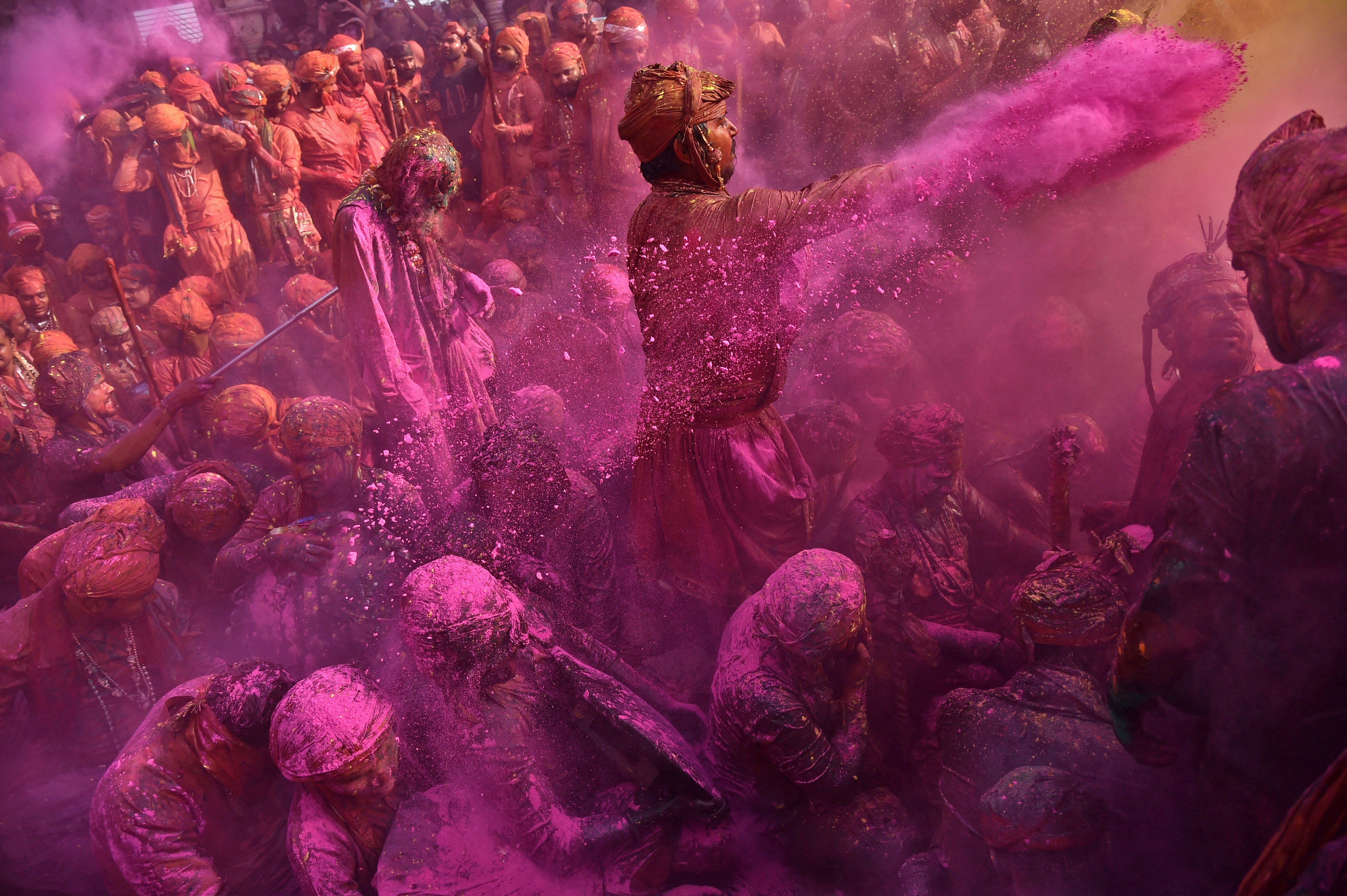 Hindu devotees take part in the religious festival of Holi inside a temple in Nandgaon village, India