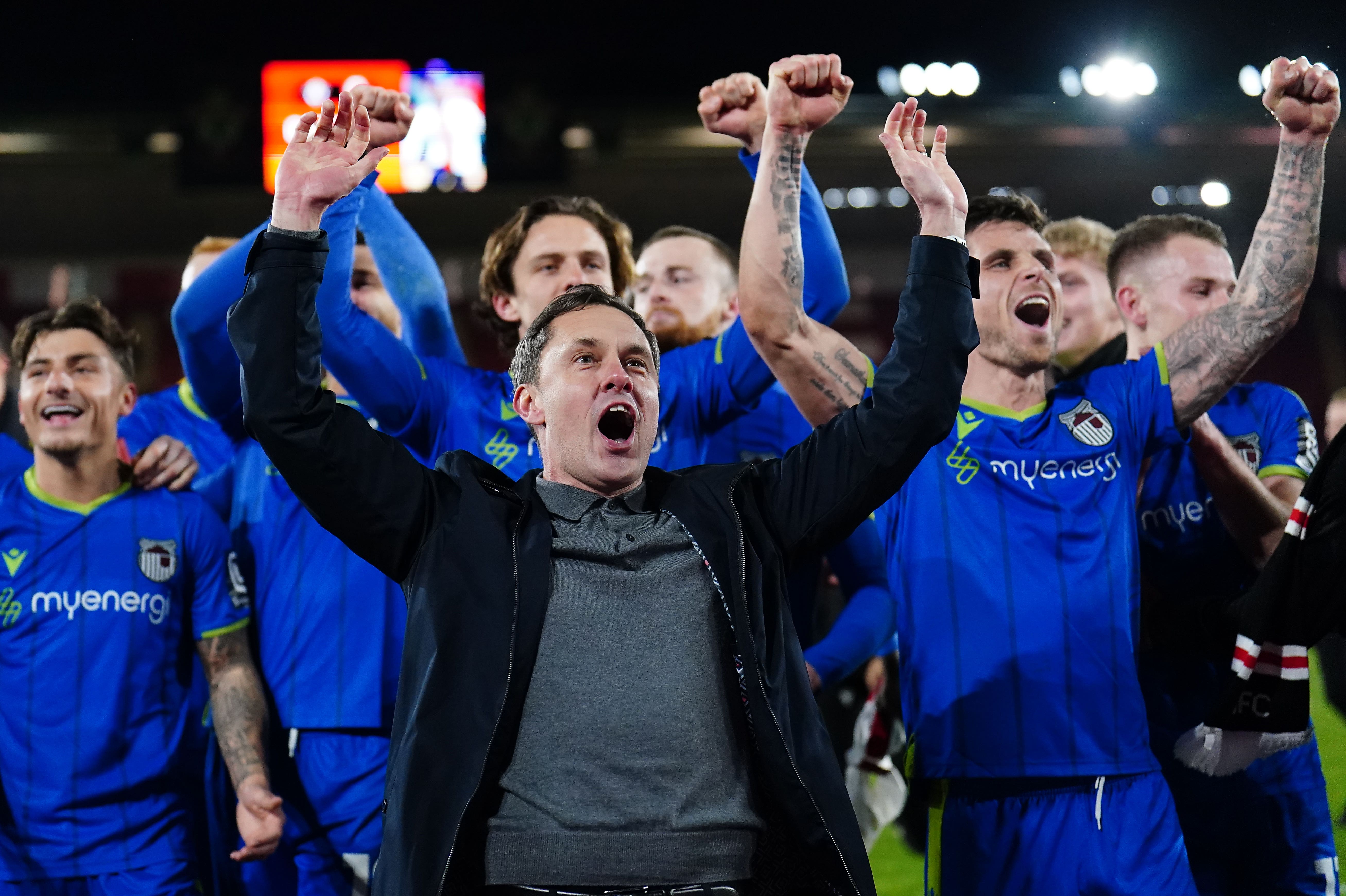 Grimsby players and manager Paul Hurst celebrate a famous win (Zac Goodwin/PA)