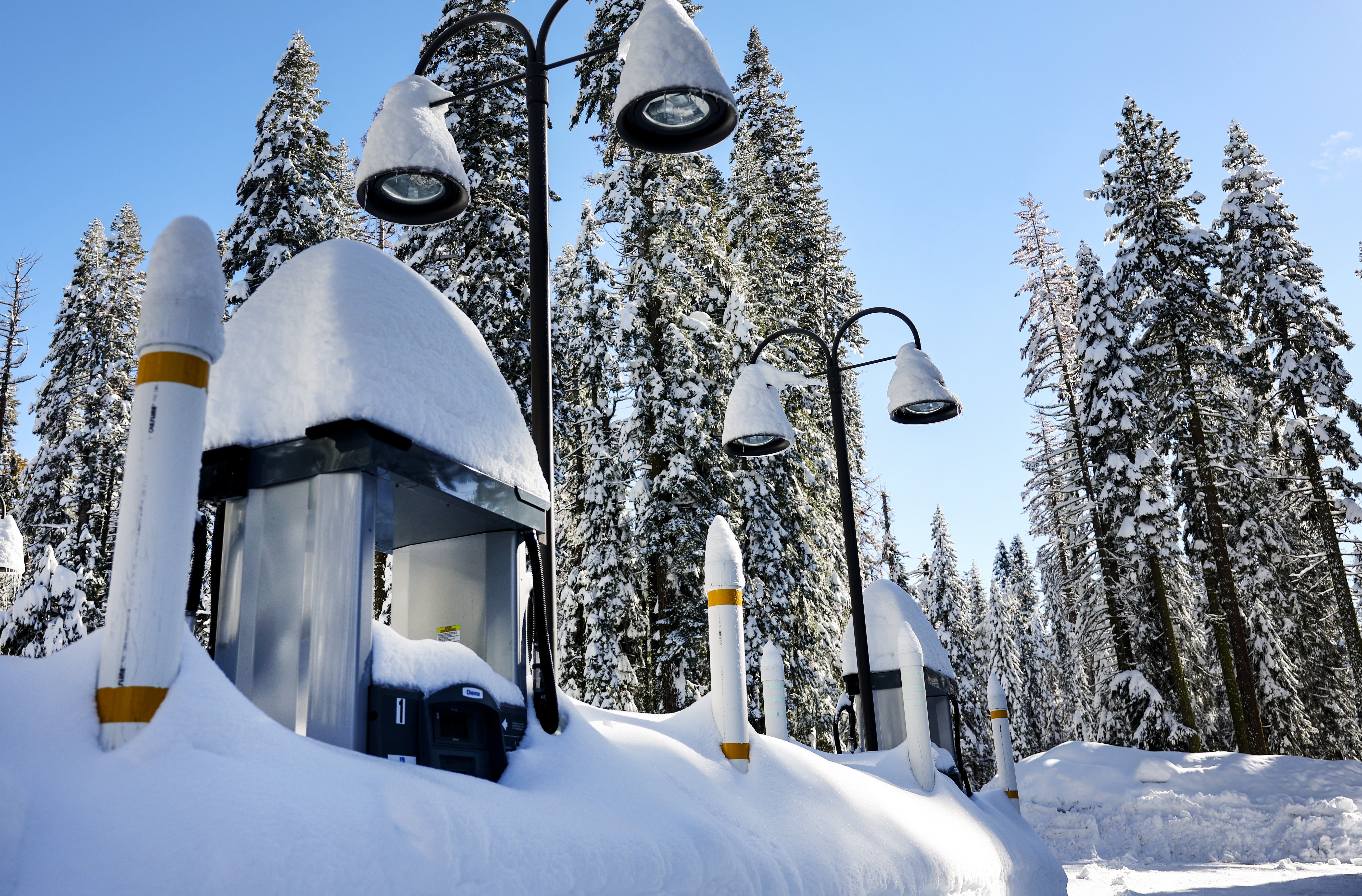 Gas pumps are partially buried in snow, at a service station closed for the winter, after a series of atmospheric river storms on January 20, 2023 in Yosemite National Park