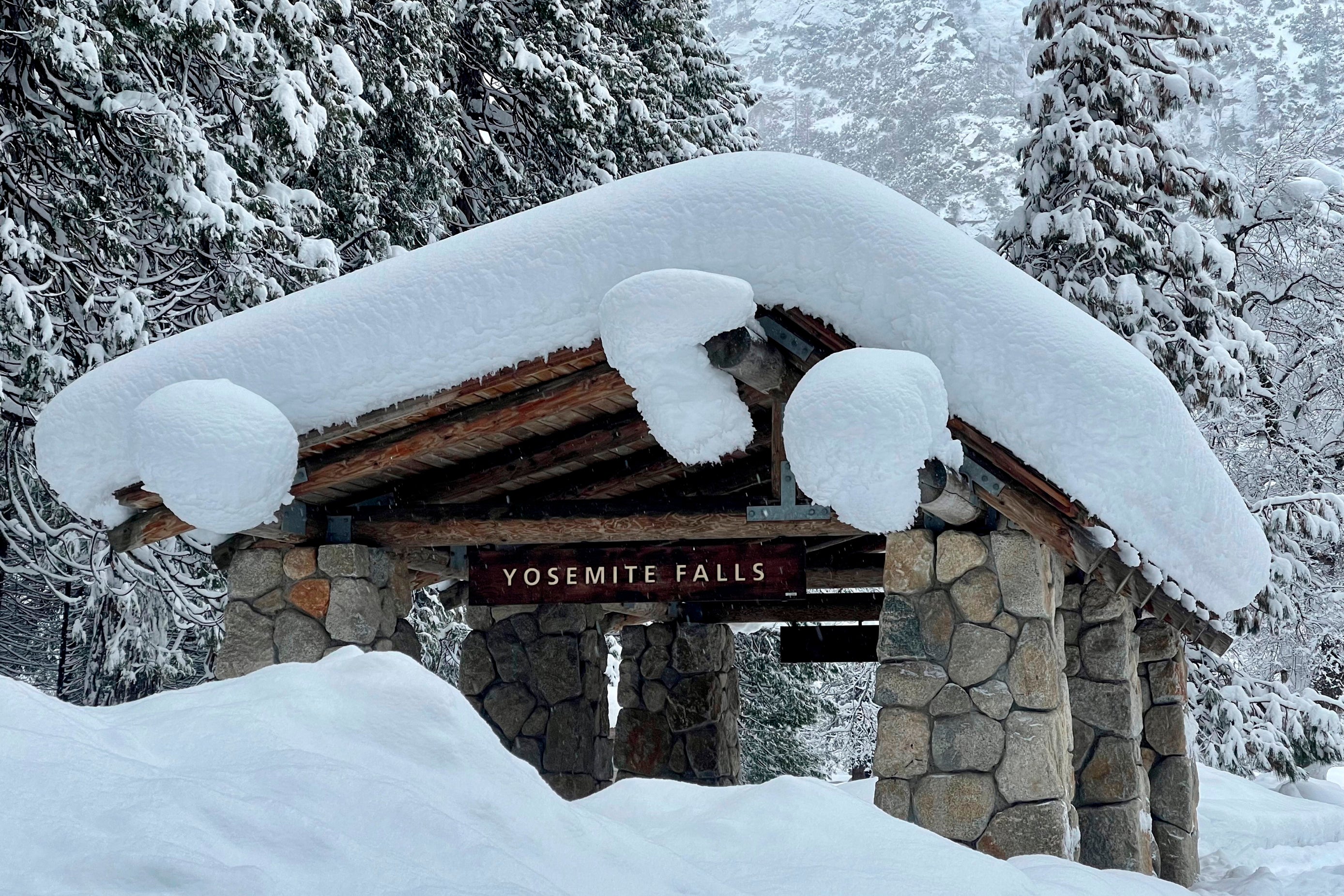 In this photo provided by the National Park Service, a structure at Yosemite Falls in Yosemite National Park, Calif., is covered in snow Tuesday, Feb. 28, 2023