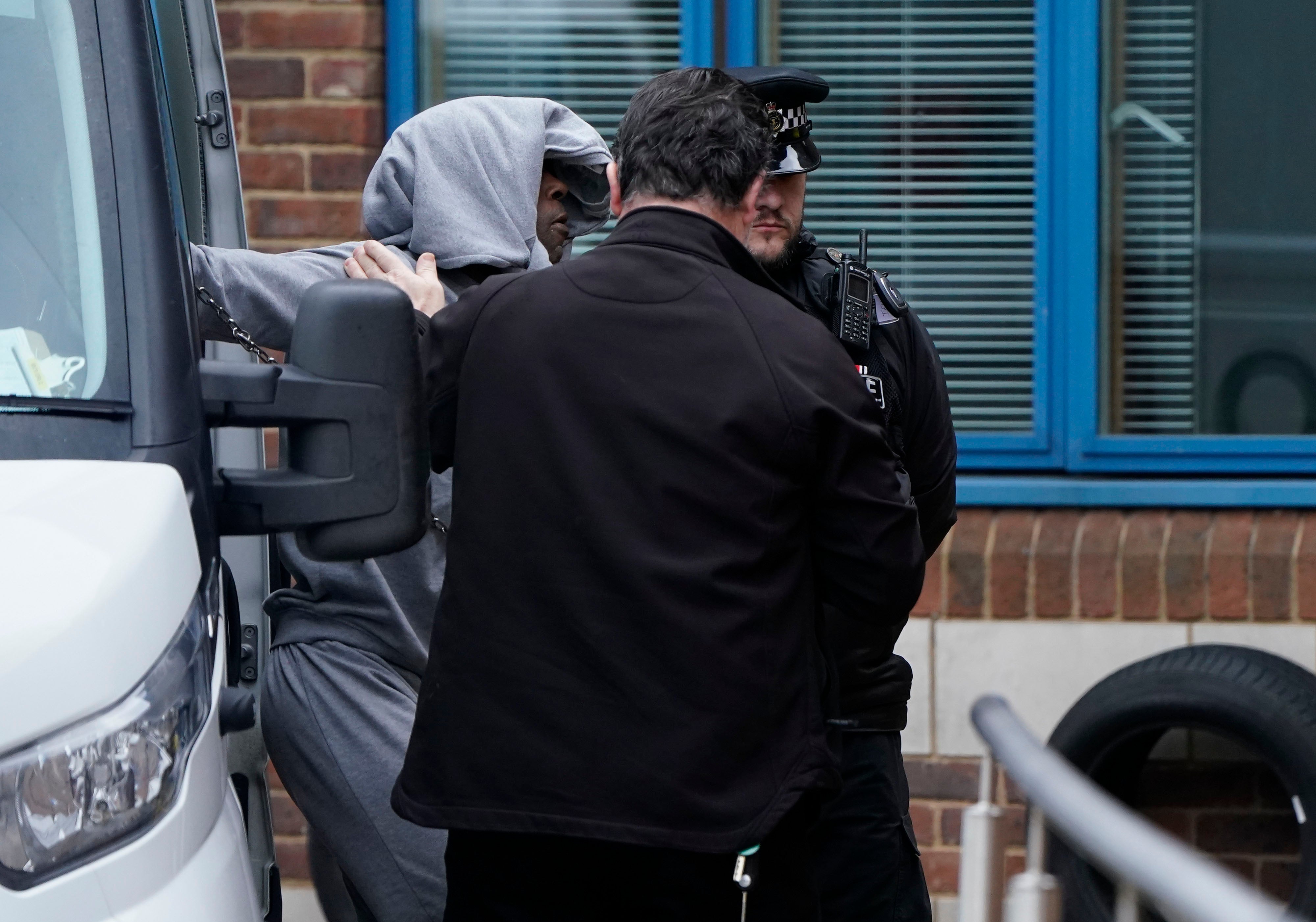 Mark Gordon is led into Crawley Police Station before being taken to Crawley Magistrates Court